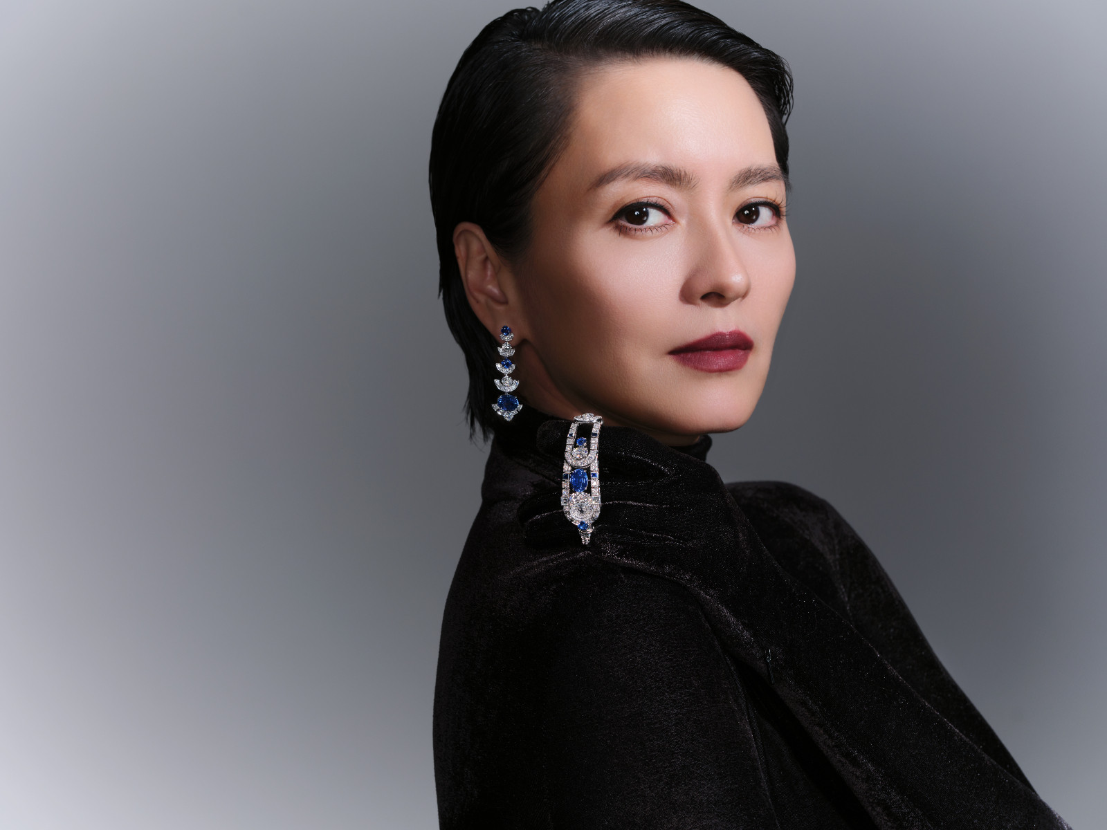 Gigi Leung wears Cartier Sixième Sens Ultramarine watch and earrings in white gold set with sapphires and diamonds; Richard Quinn top