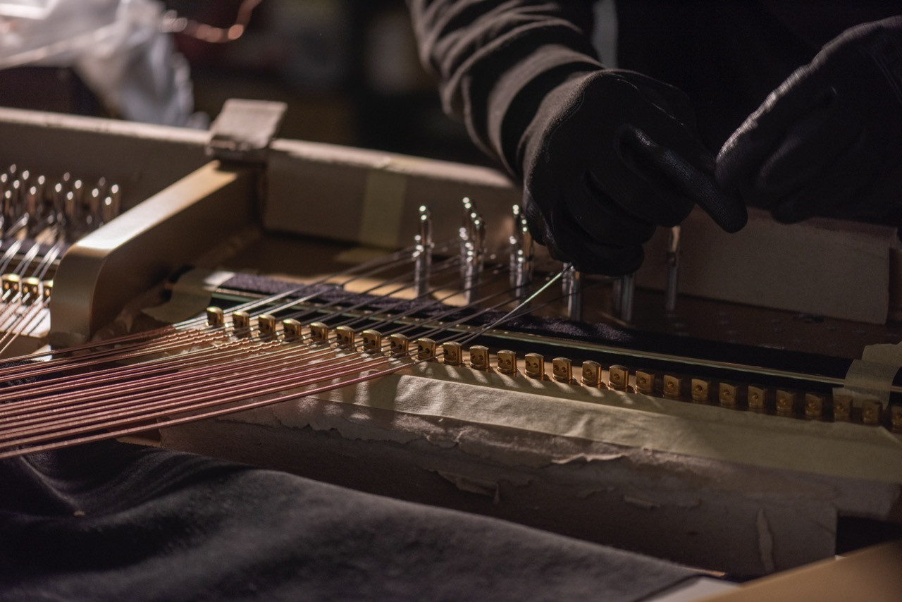 An Edelweiss craftsperson works on the string-and-pin arrangement during assembly