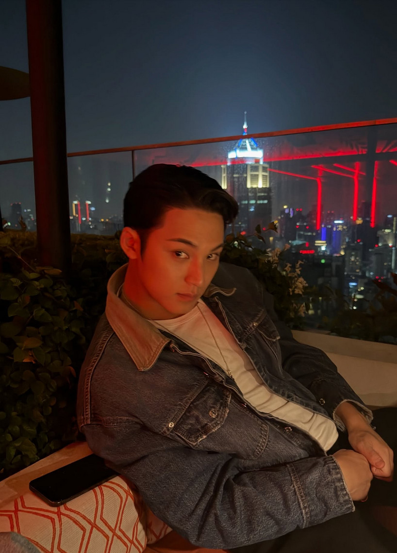 Mingyu radiates ’90s Americana sensuality in an unbuttoned denim jacket against the city lights (Photo: @min9yu_k/Instagram)