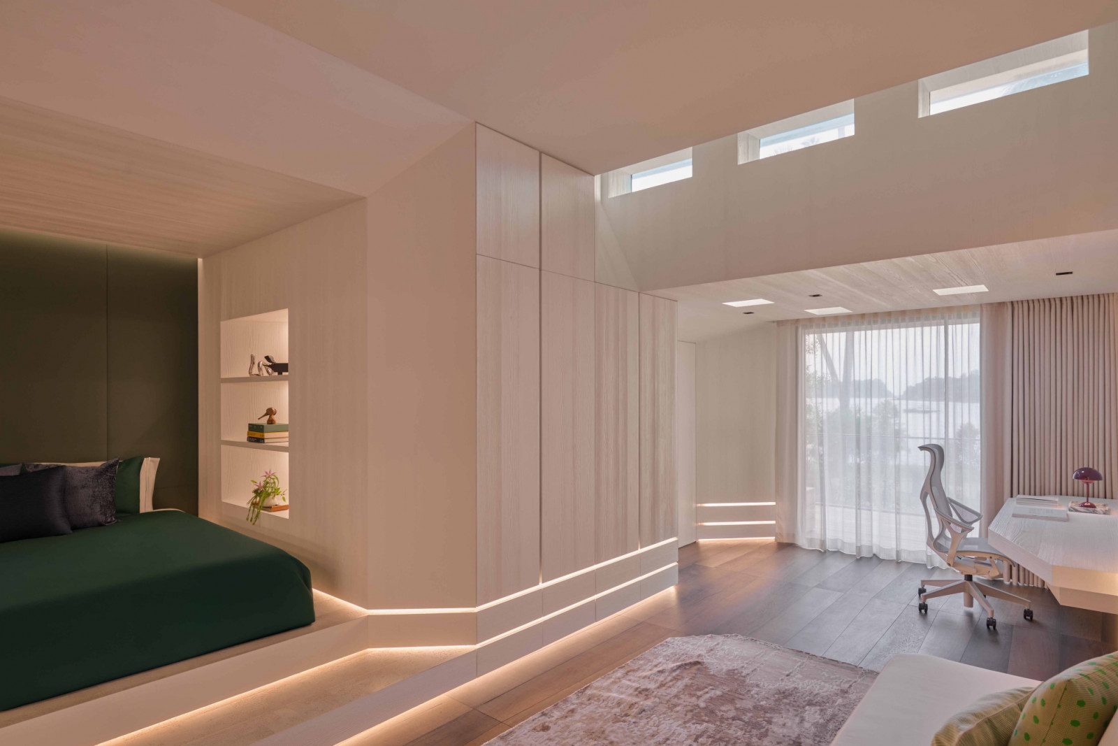 The son’s bedroom reprises the custom carpentry in a more angular form, while clerestory windows linked to the pool above send rippling light across the room
