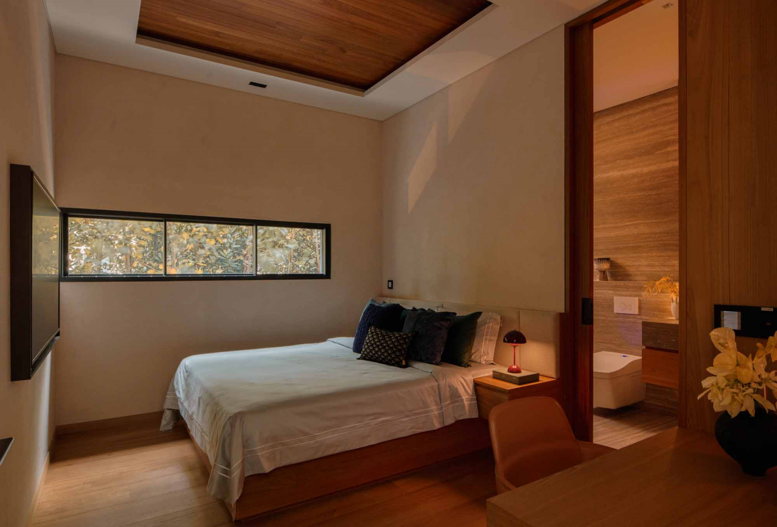 Warm timber fittings give the guest bedroom a calm and intimate atmosphere