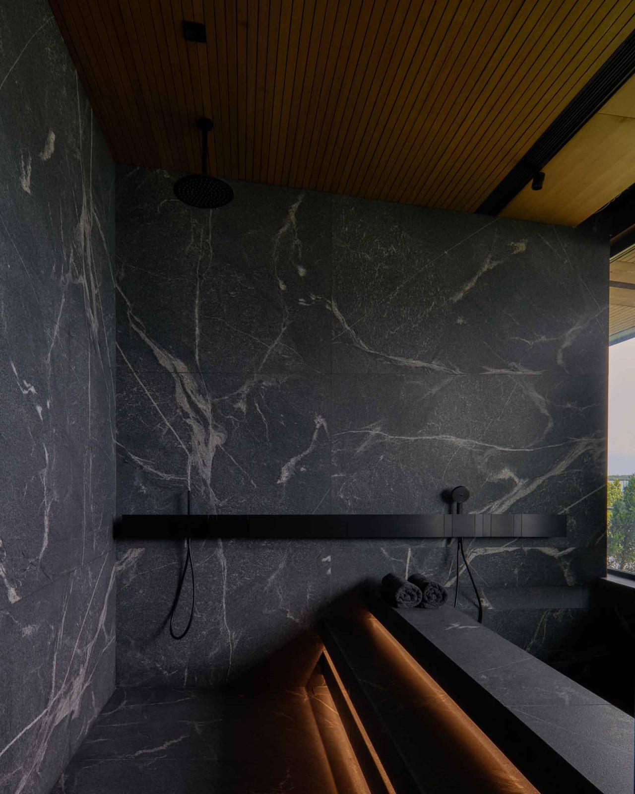 New American Black marble in leather finish at the opposite end of the master bathroom contrasts with the lighter marble wall