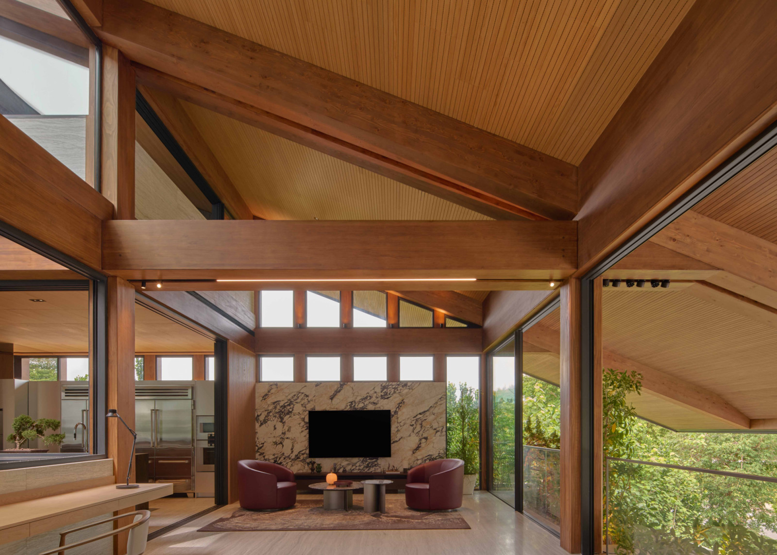 Set beneath the timber pavilion’s five-metre cantilever, the family lounge features a Wave coffee table and Moon armchairs by Giulio Marelli, supplied by Xtra Designs, against a Calacatta Vagli Viola marble feature wall by Kstone