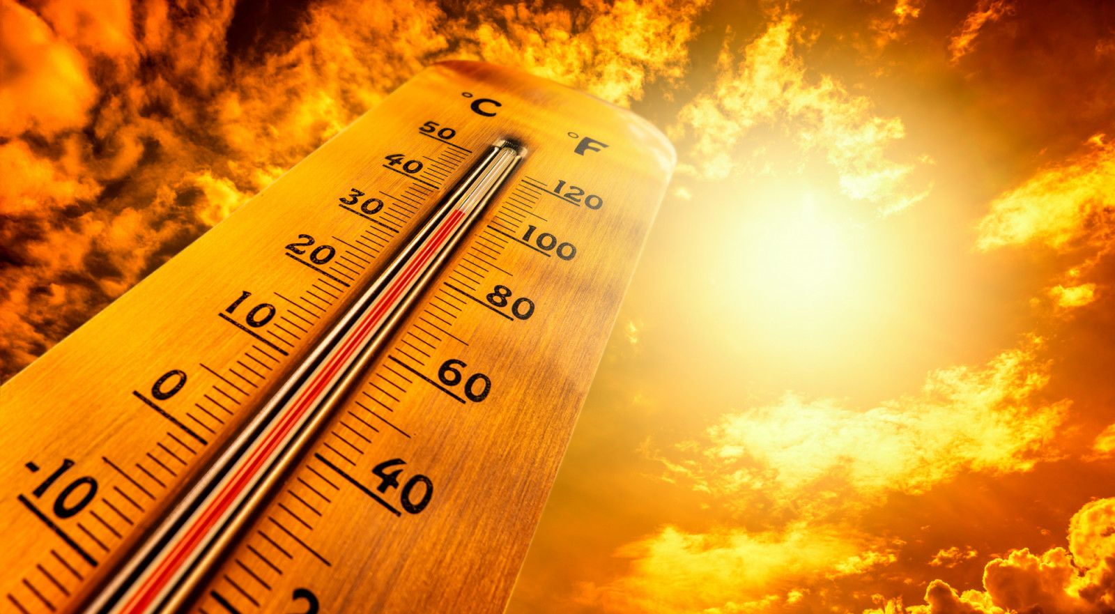 Thermometer showing tropical heat and sky with hot sun rays in Celsius and Fahrenheit (photo: SimpleImages / Getty Images)