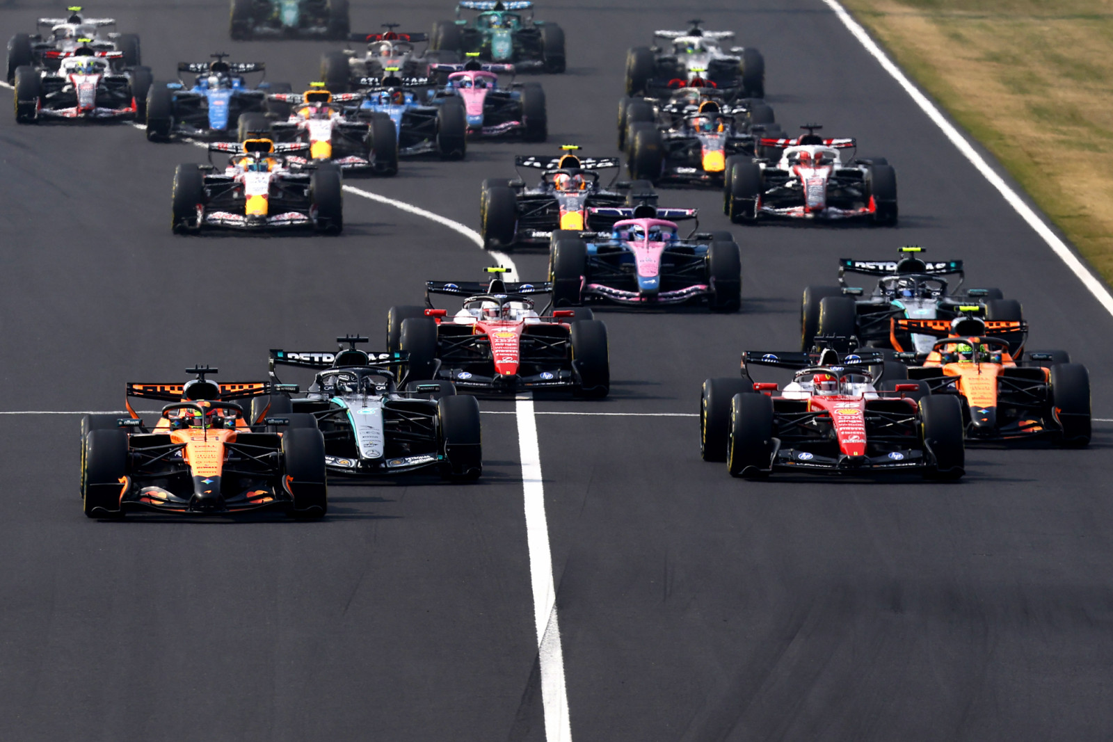 SUZUKA, JAPAN - MARCH 29: Oscar Piastri of Australia driving the (81) McLaren MCL40 Mercedes leads George Russell of Great Britain driving the (63) Mercedes AMG Petronas F1 Team W17 Charles Leclerc of Monaco driving the (16) Scuderia Ferrari SF-26 and the rest of the field at the start during the F1 Grand Prix of Japan at Suzuka Circuit on March 29, 2026 in Suzuka, Japan. (Photo by Mark Thompson/Getty Images)