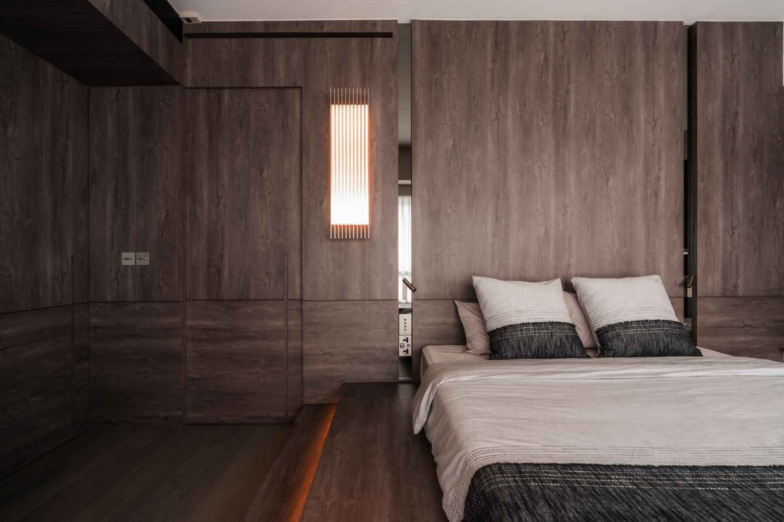 The master bedroom features an elevated bed platform and Mario Tsai’s Grid light, which reinforces the room’s linear aesthetic