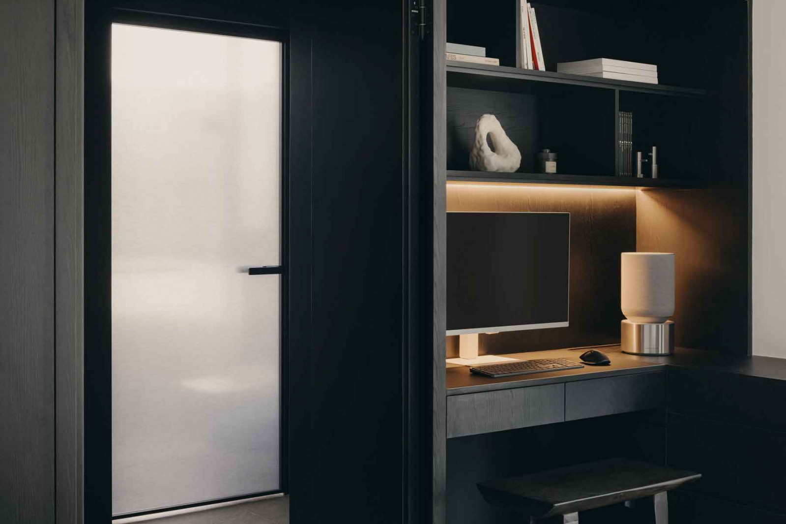 A gently lit study nook with overhead bookshelves