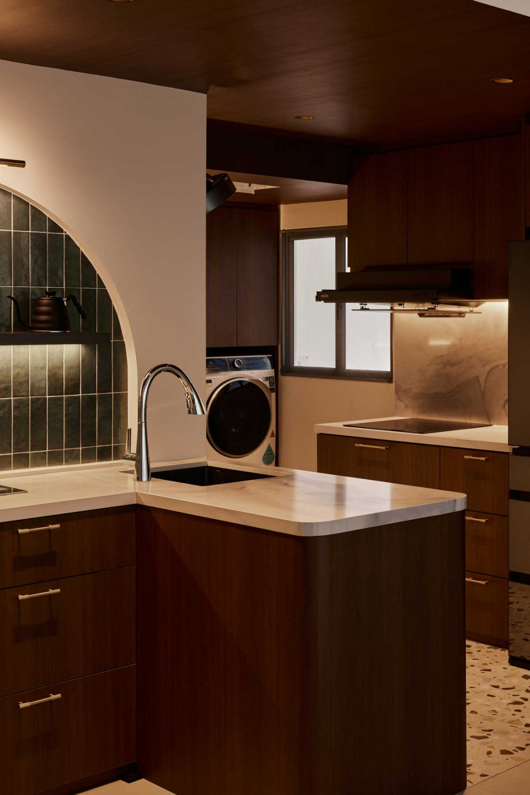 A quiet harmony of curves, stone and timber defines the working end of the kitchen, where sculptural flow meets everyday function