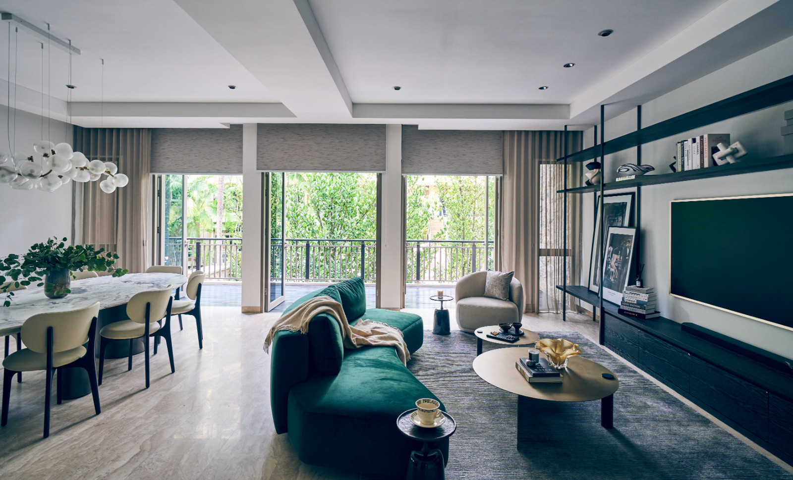 The living and dining spaces open out to verdant greenery outside