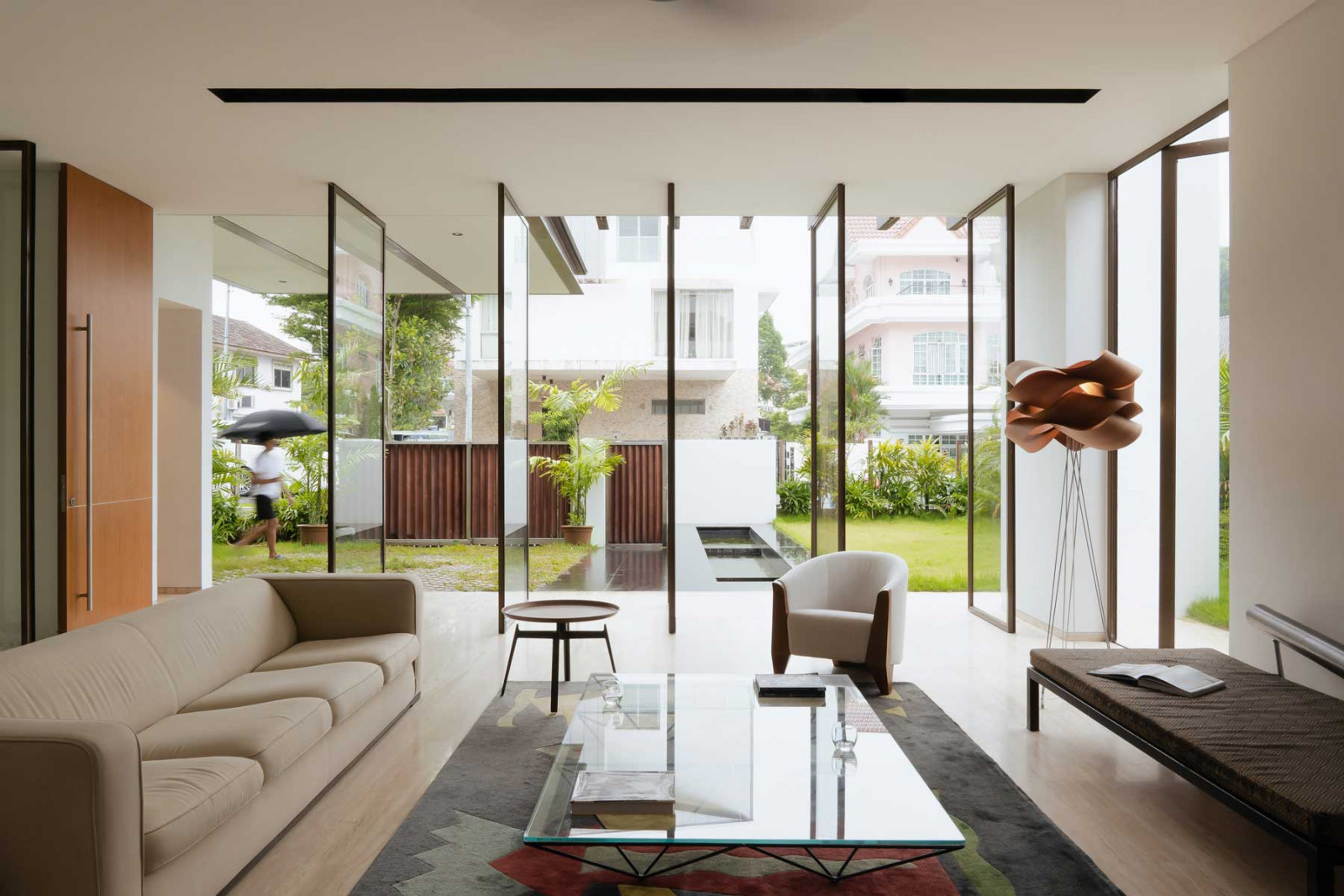 Full-height glass pivot doors merge the outdoor areas with the interio