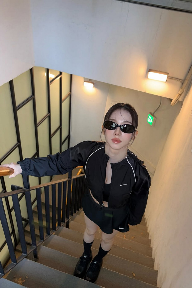 Karina in a Nike track jacket and pleated mini skirt elevated by bold oval sunglasses (Photo: @katarinabluu/Instagram)