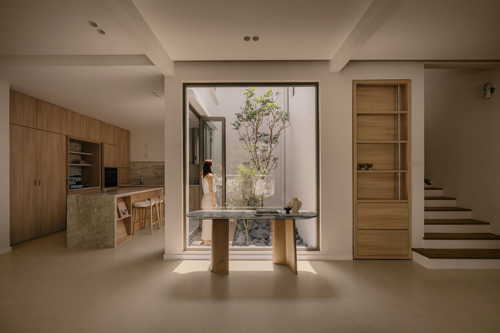 The ground floor from the entrance, with the indoor courtyard framed by a large picture window at the centre