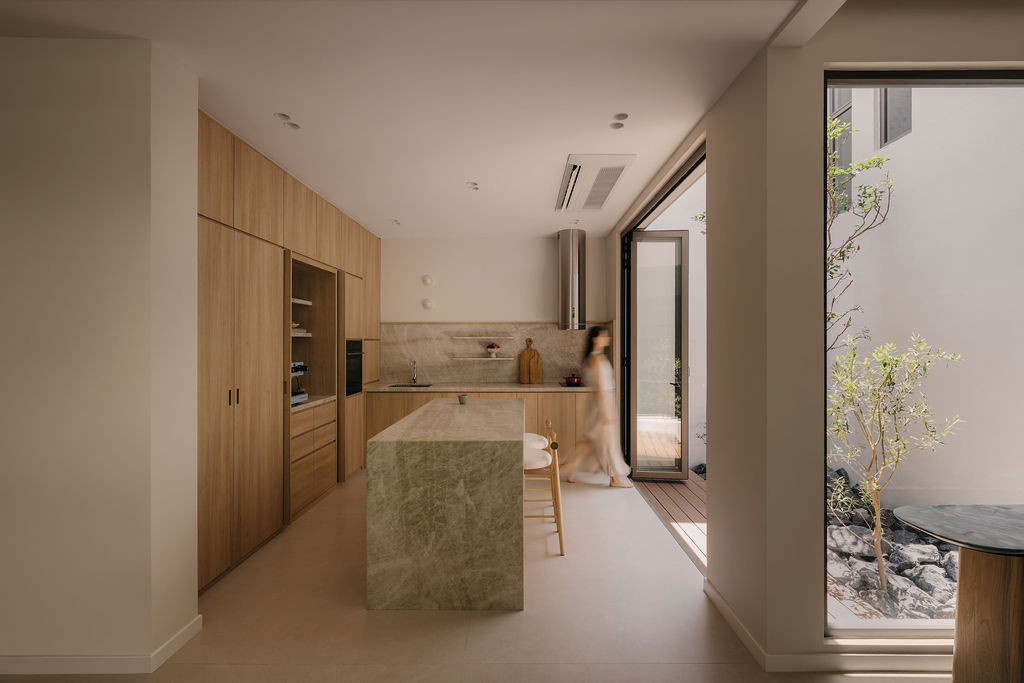 The kitchen from the rear, with the indoor courtyard and its Sputnik planting visible through the door to the right