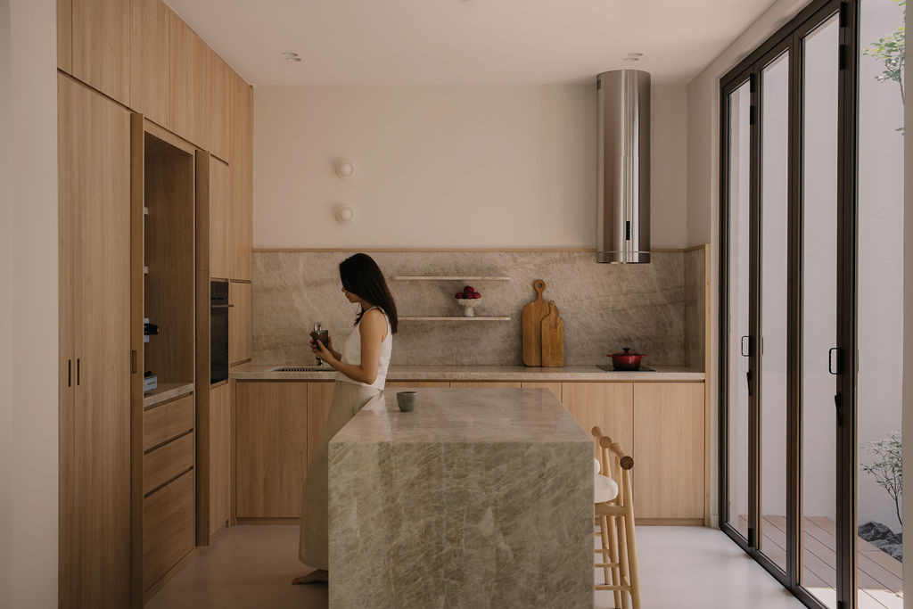 The dry kitchen with a Taj Mahal quartzite island and wood-textured laminate cabinetry