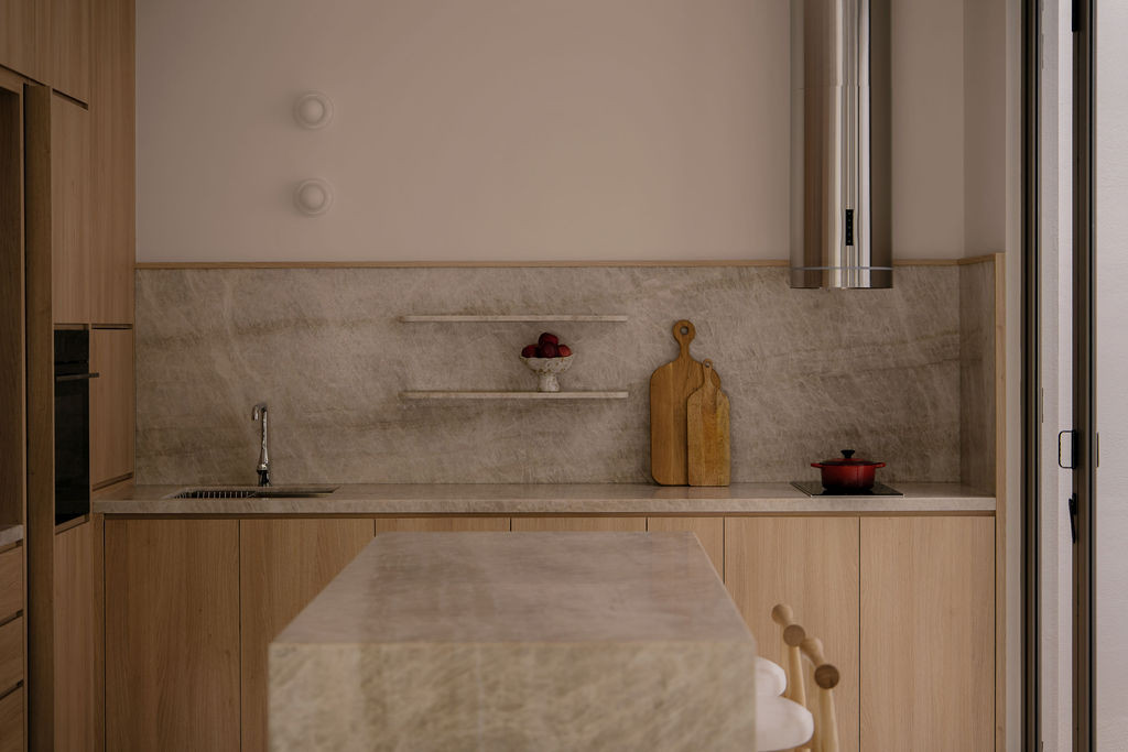 A detail of the dry kitchen counter and backsplash in Taj Mahal quartzite, with floating stone shelves above