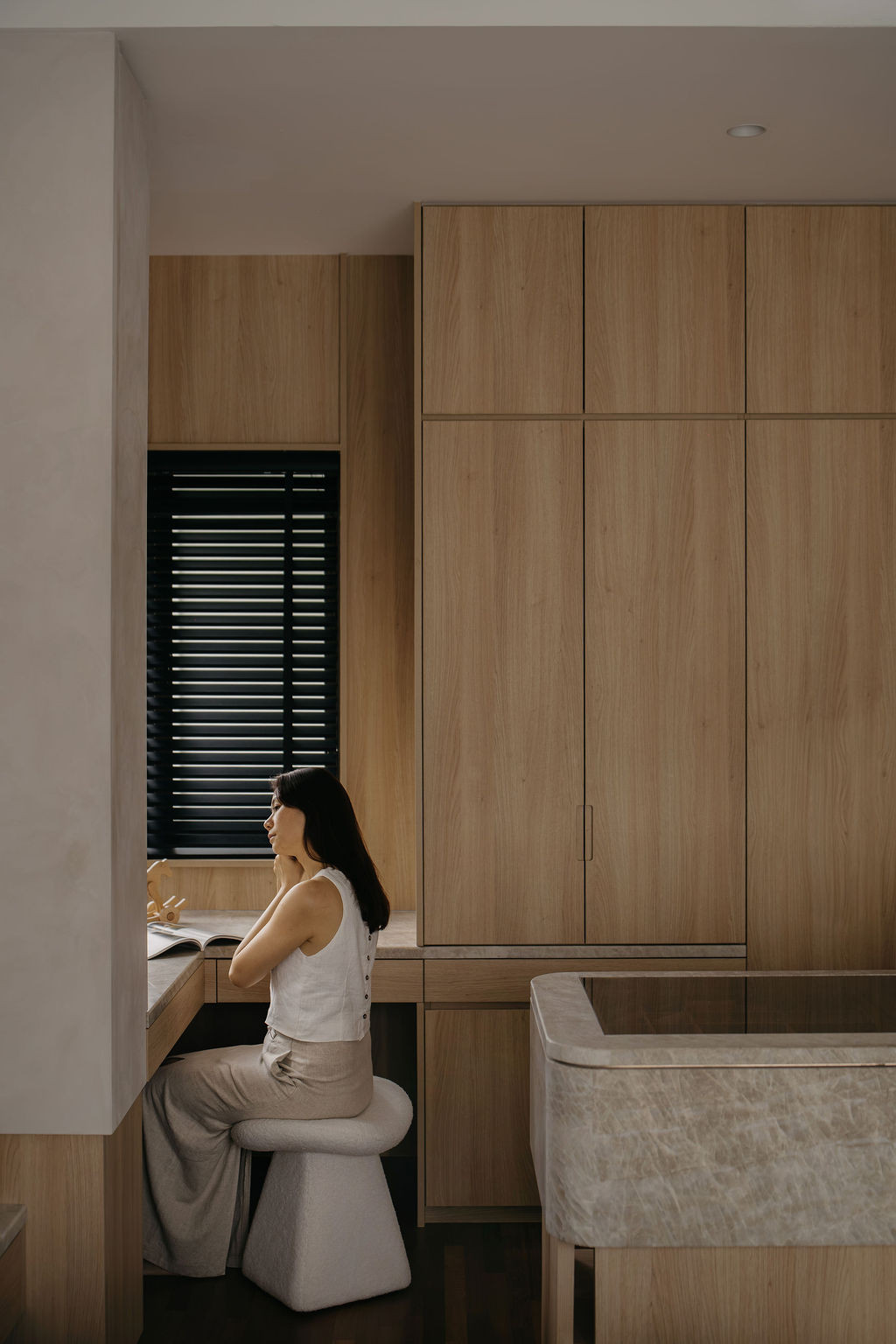 The master bedroom’s dressing area has a built-in desk and full-height wood-textured laminate cabinetry