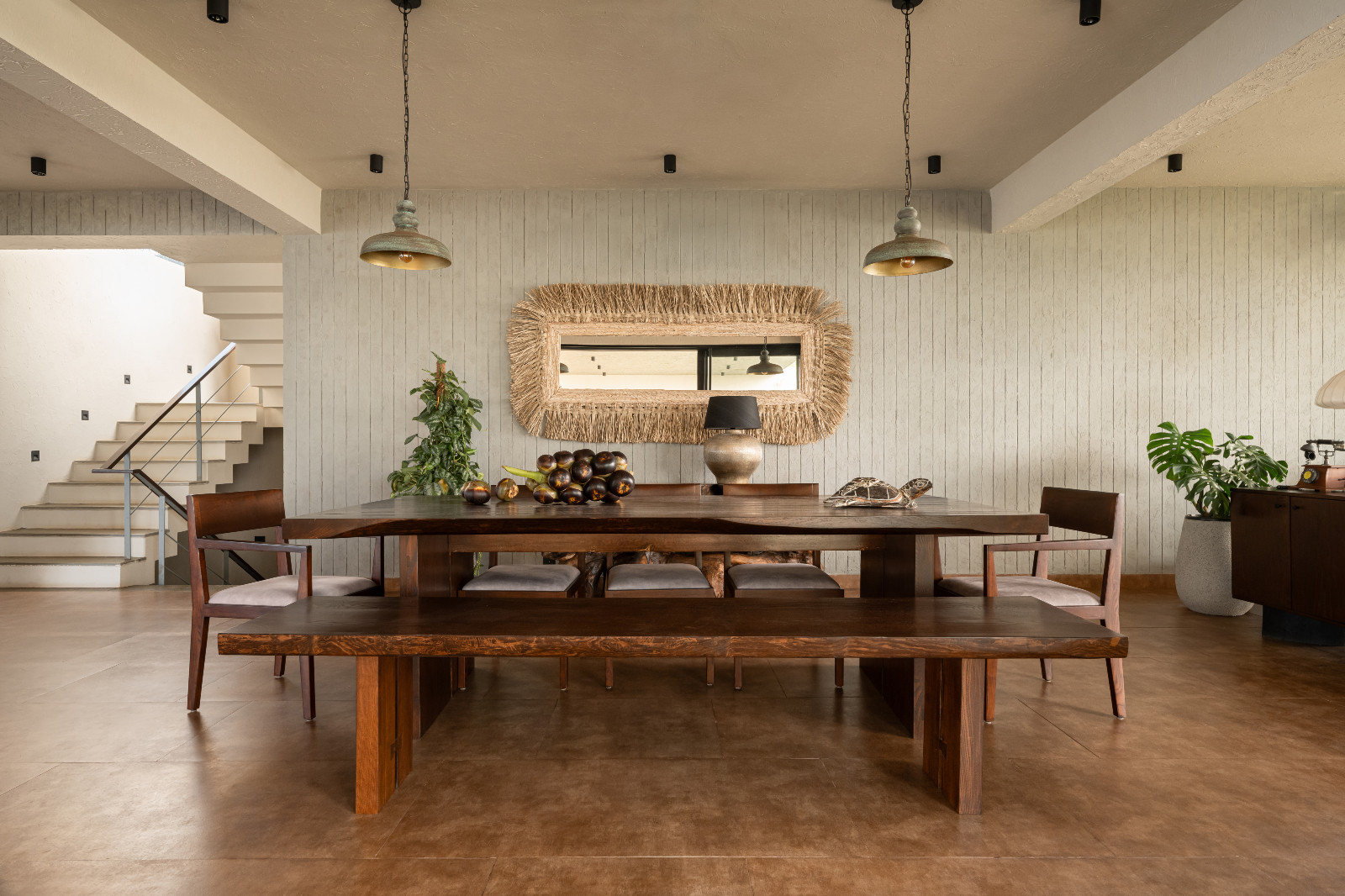 The dining room and stairway in a Karnataka, India home designed by Thomas Parambil Architects