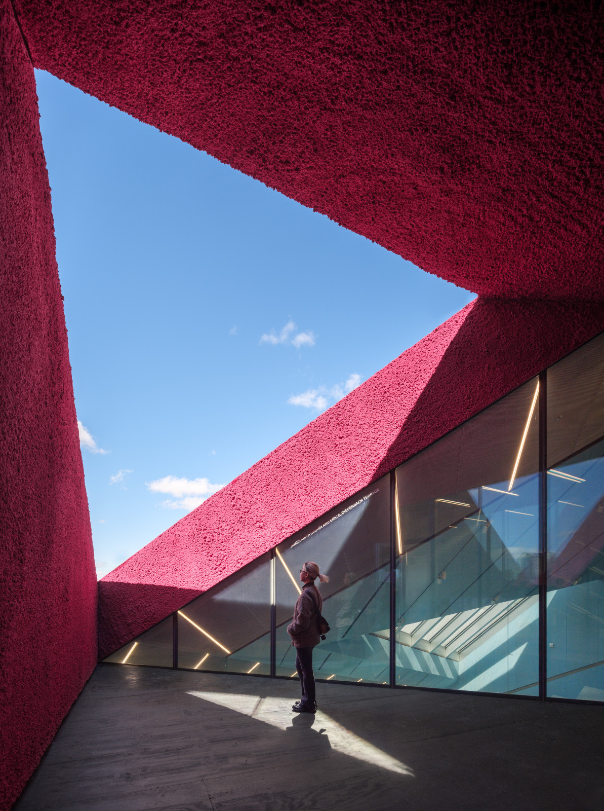 A terrace of the OMA addition, its surfaces clad in a deep magenta textured material (Photo: New Museum)