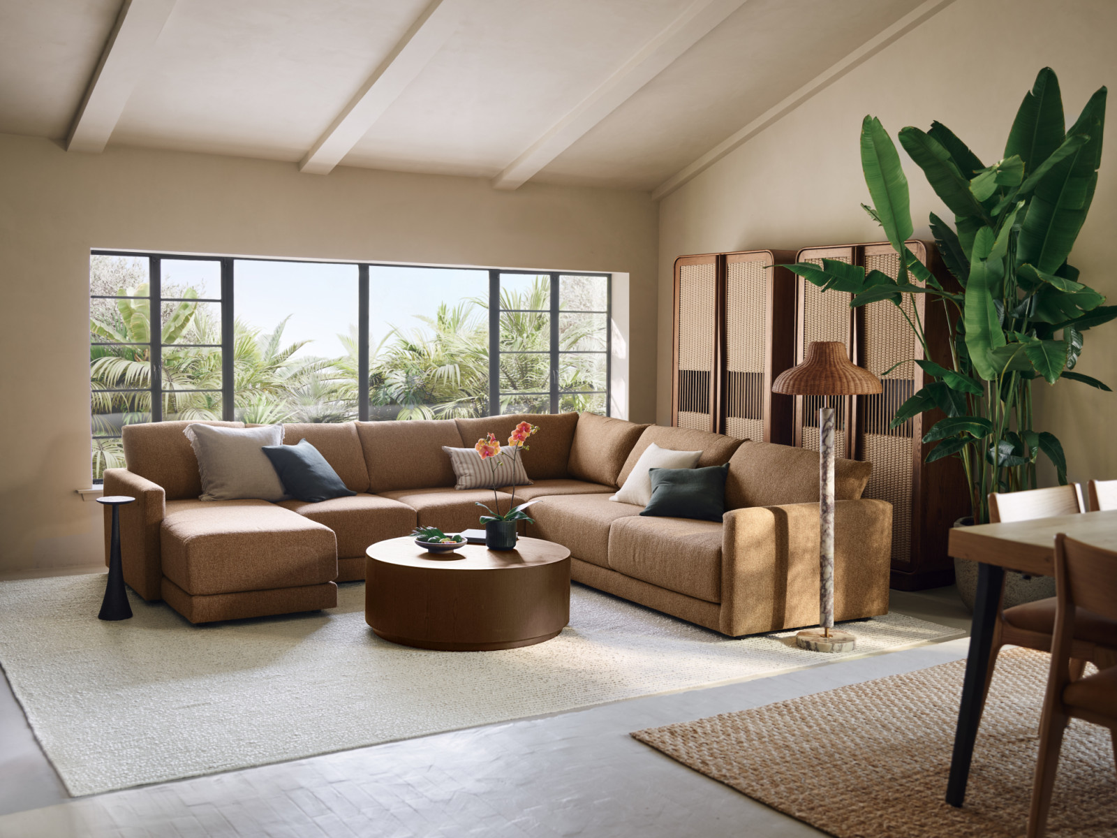 This living room channels the serene tropics of a Bali retreat. The Gather sectional anchors the space with its expansive, extra-plush proportions, offering a deep-seated sanctuary for relaxation. Complementing the sofa’s modern silhouette, the Talay cabinet introduces a rhythmic, organic warmth through its oak framing and hand-woven Danish cord panels. Together, these pieces create a sophisticated sanctuary that celebrates rich textures and architectural harmony (Photo: courtesy of Crate and Barrel)
