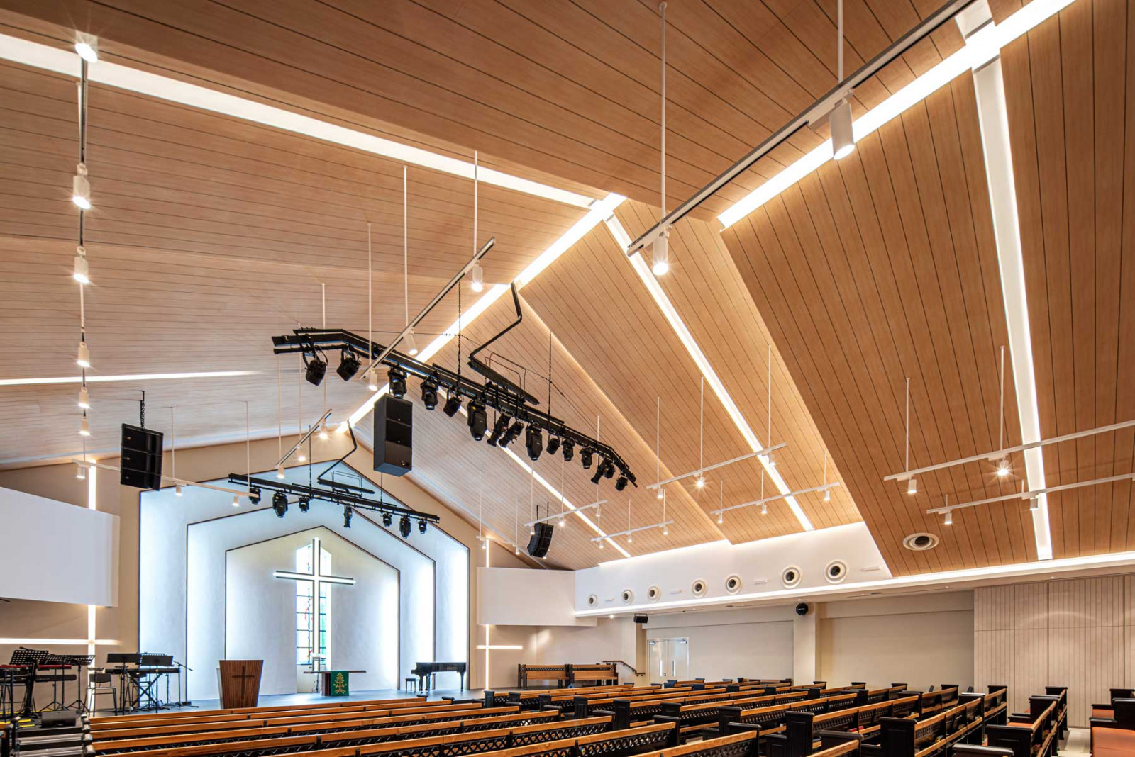 The renewed sanctuary at Bedok Methodist Church pairs restored teak pews with a luminous timber-lined ceiling