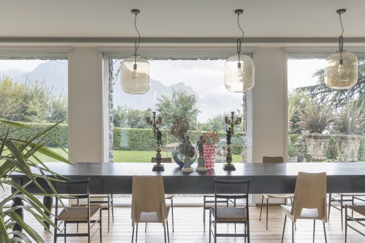 Te dining table is set with Parisian bronze candlesticks circa 1840, Gae Aulenti’s Geacolor vase for Venini, Ercole Barovier’s Lenti series vase, and a pair of Moor-shaped chambersticks in bronze