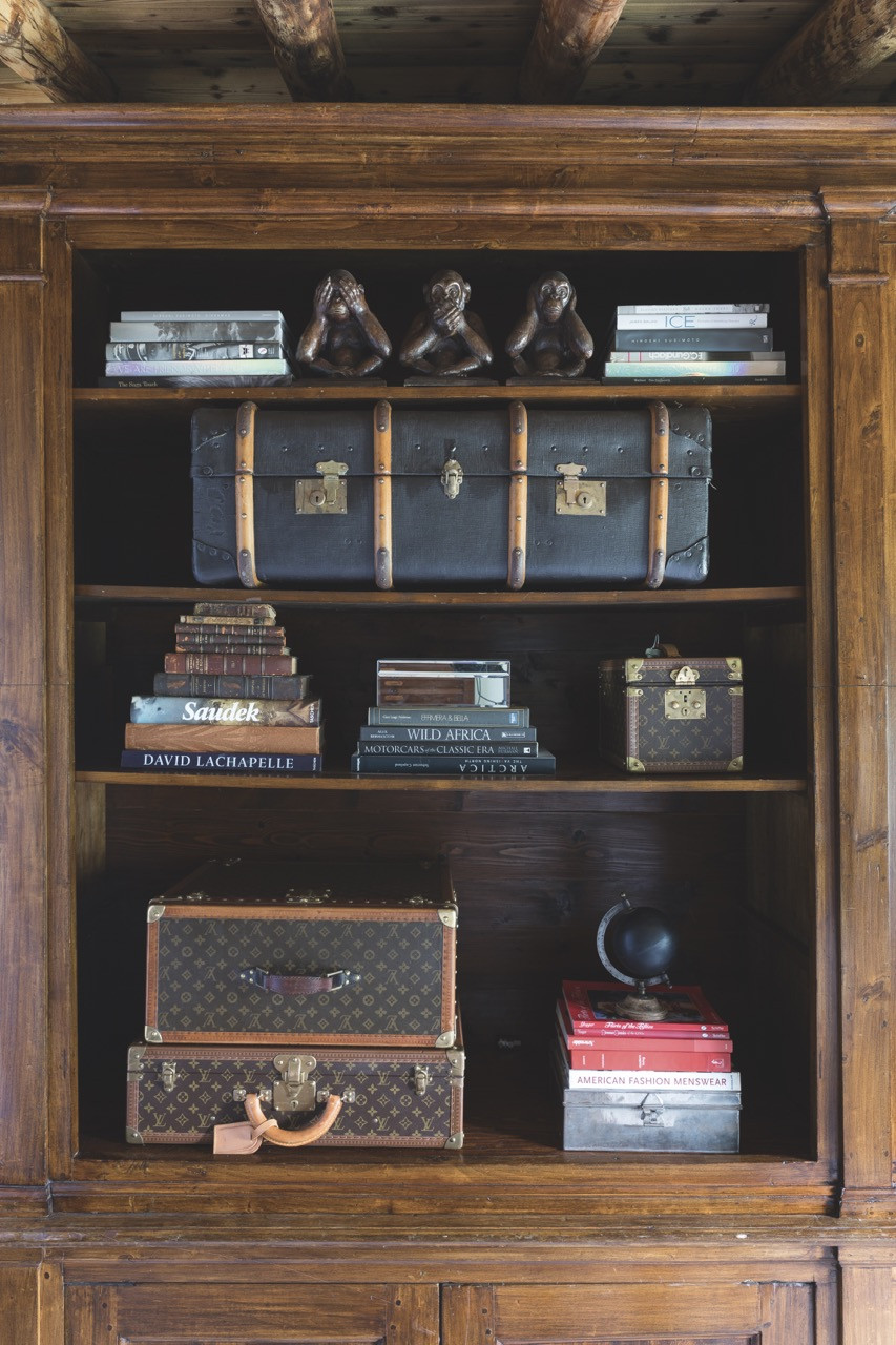 These shelves display Louis Vuitton suitcases and a vanity case