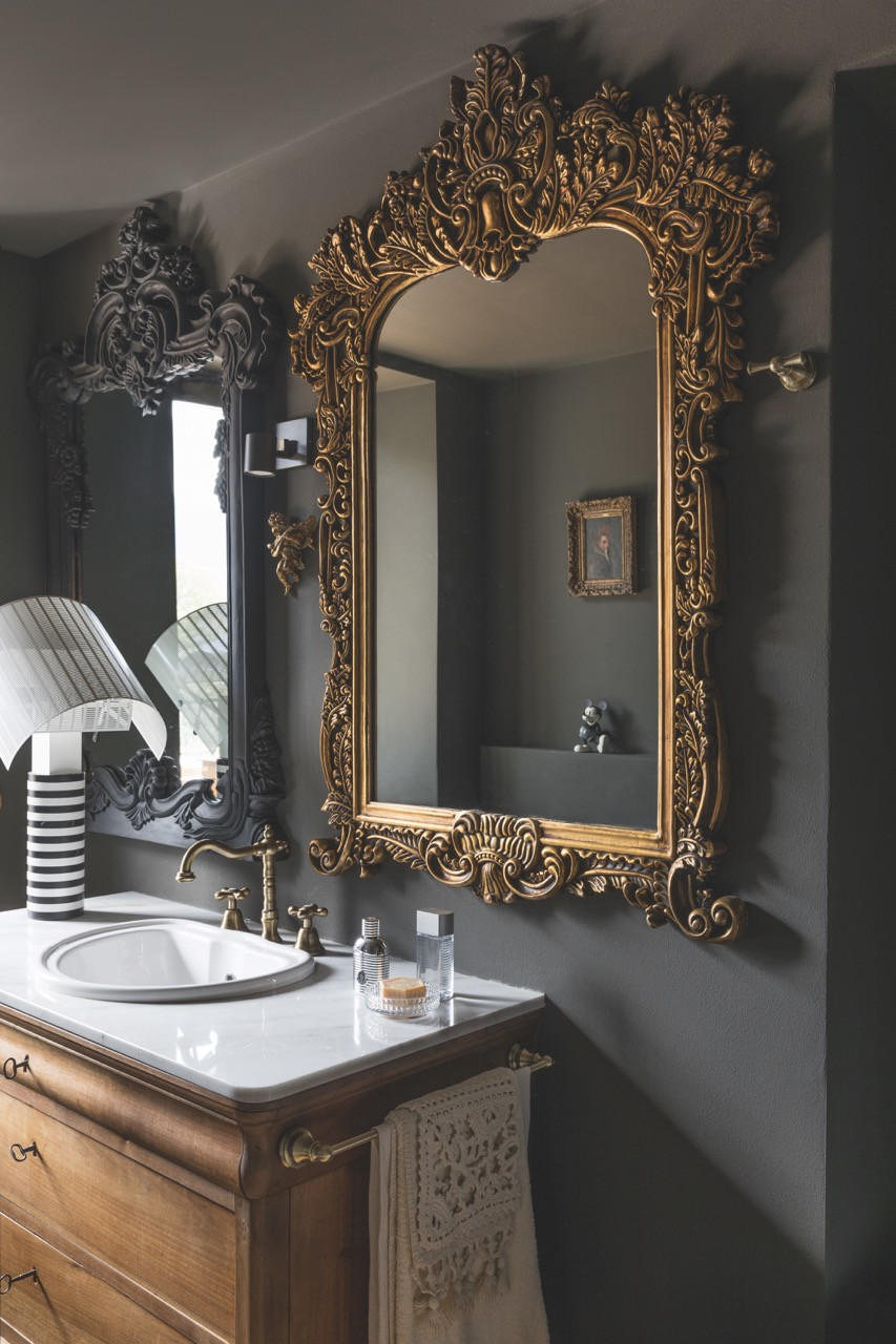 This bathroom is adorned with an ornate framed mirror and Mario Botta’s Shogun lamp for Artemide