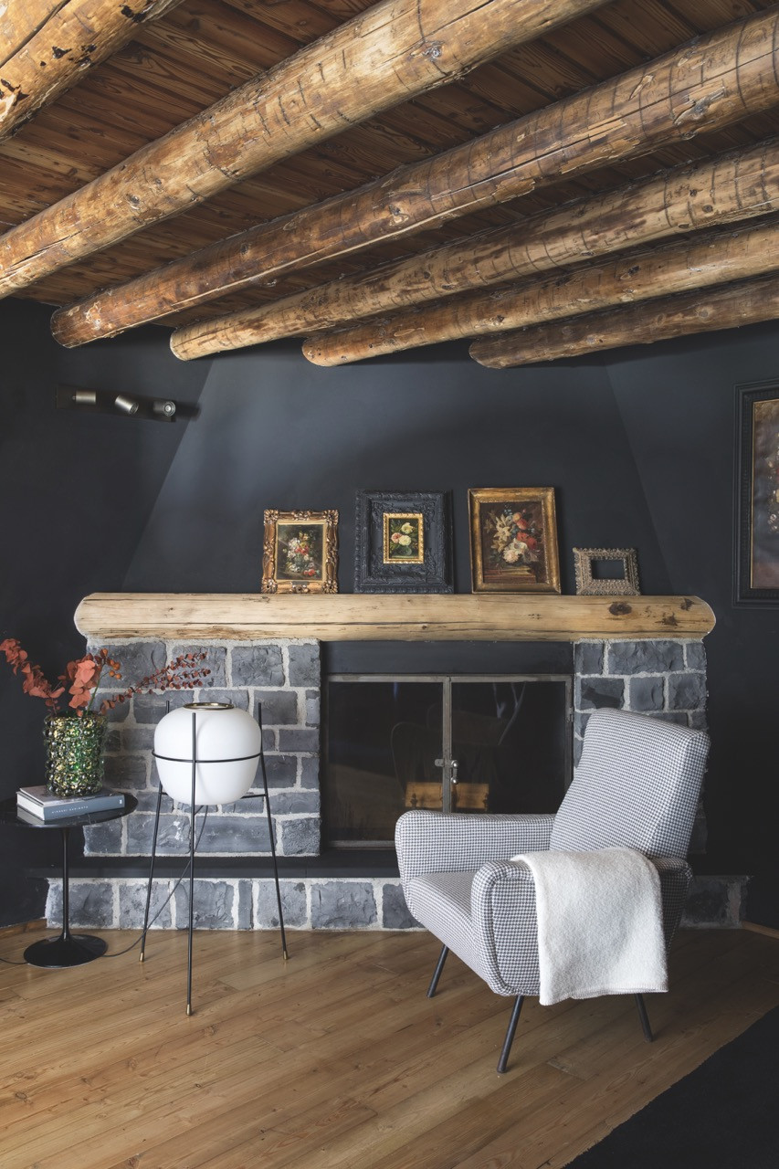 A 1960s Stilnovo floor lamp stands beside a 1960s houndstooth armchair in the master bedroom’s fireplace corner