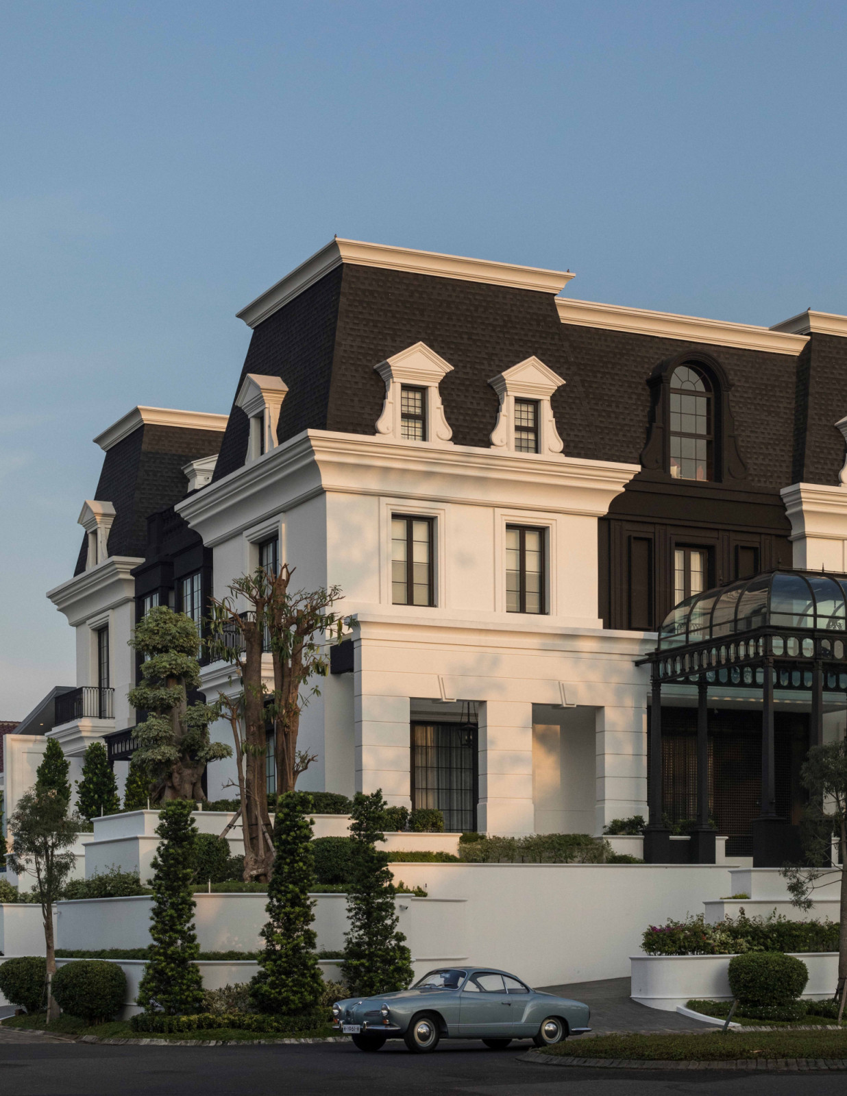 The exterior of The Continental echoes old-world European architecture, framed by conifer-lined landscaping