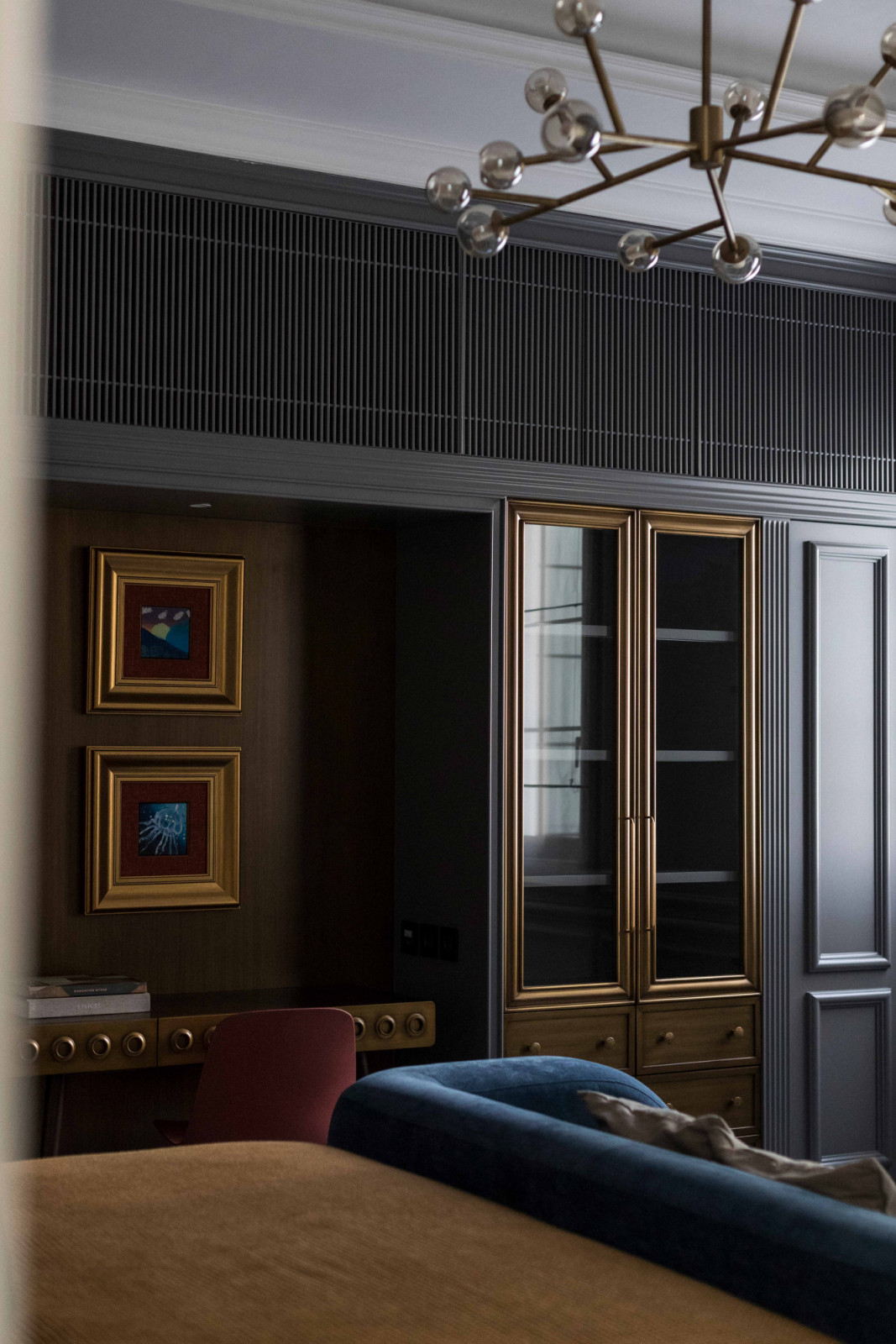 Brass-framed cabinetry and a writing desk imbue the study with a quiet sophistication;