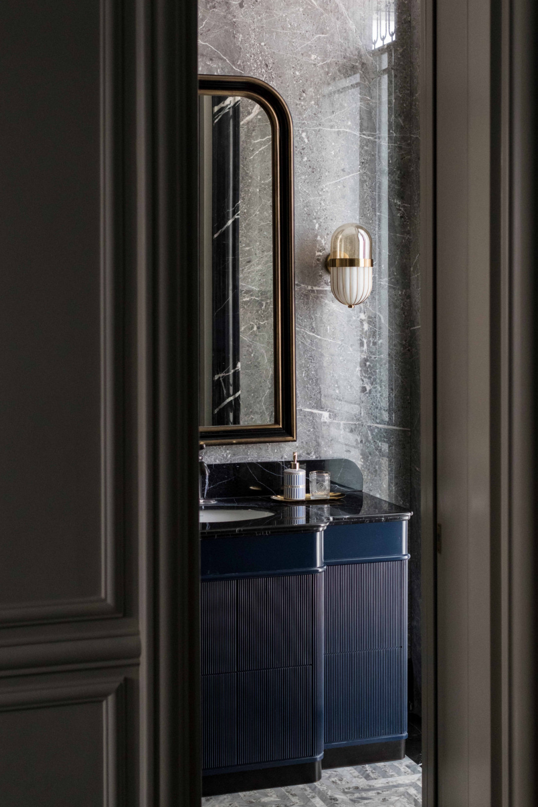 A glimpse into the bathroom at The Continental reveals navy blue cabinetry
