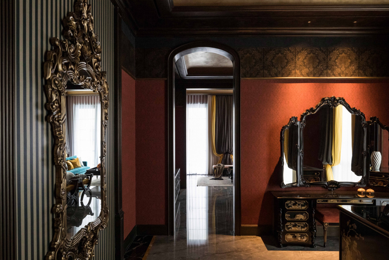 Striped wallpaper, intricate mirrors and terracotta walls continue the home’s old-world aesthetic
