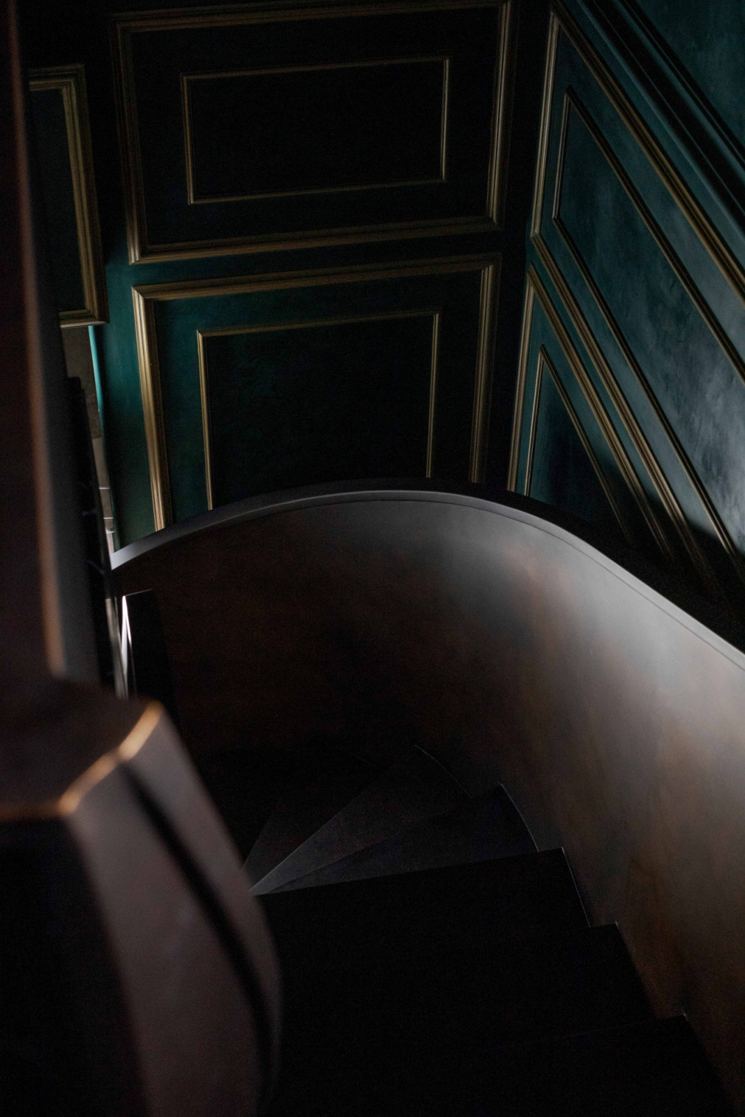 A dark, handsome view unfolds as one descends the spiral staircase in the master suite