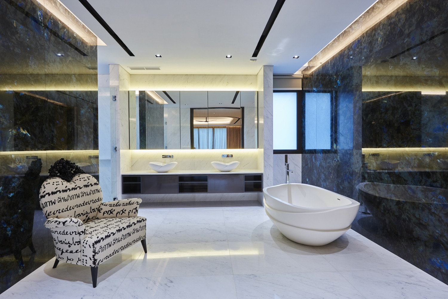 The sleek master bathroom features a double vanity and a sculptural freestanding tub