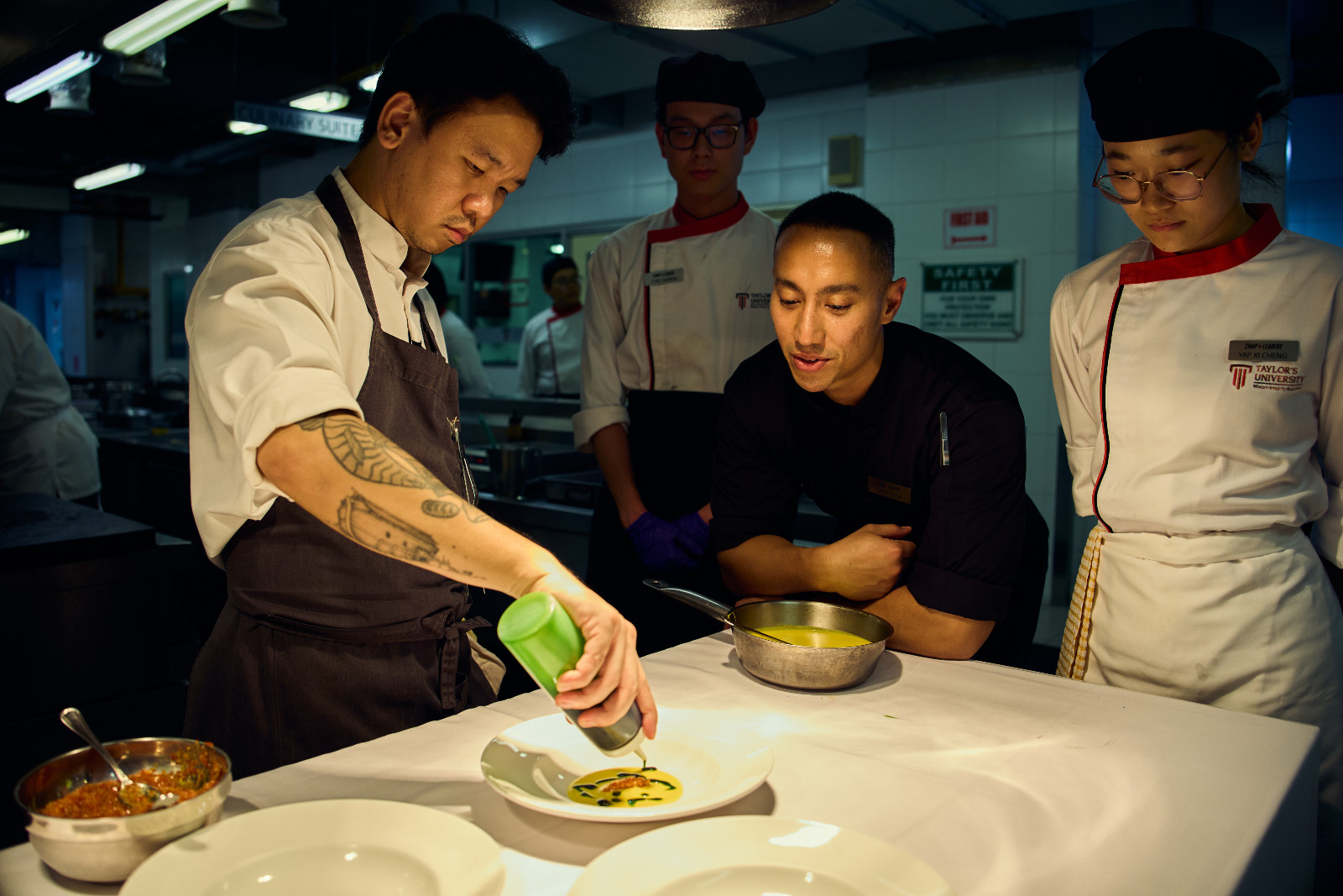 Chef Hans demonstrating technique as Chef Yuda watches on with students