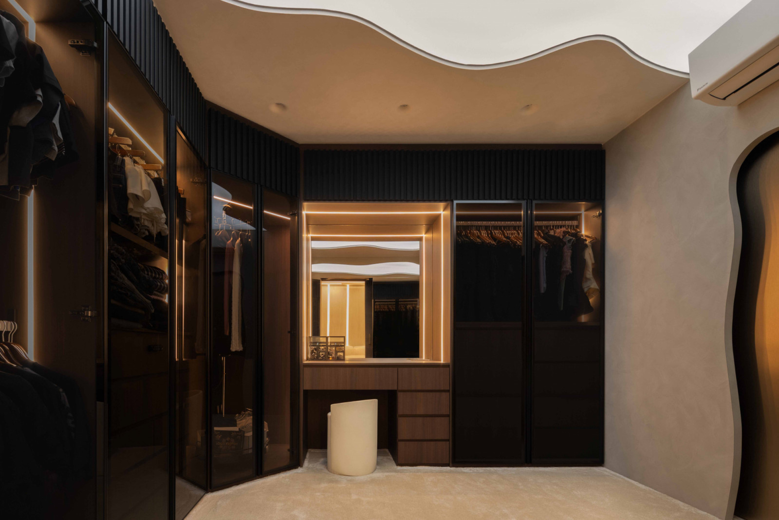 The walk-in wardrobe is treated as both storage and an extension of the living experience