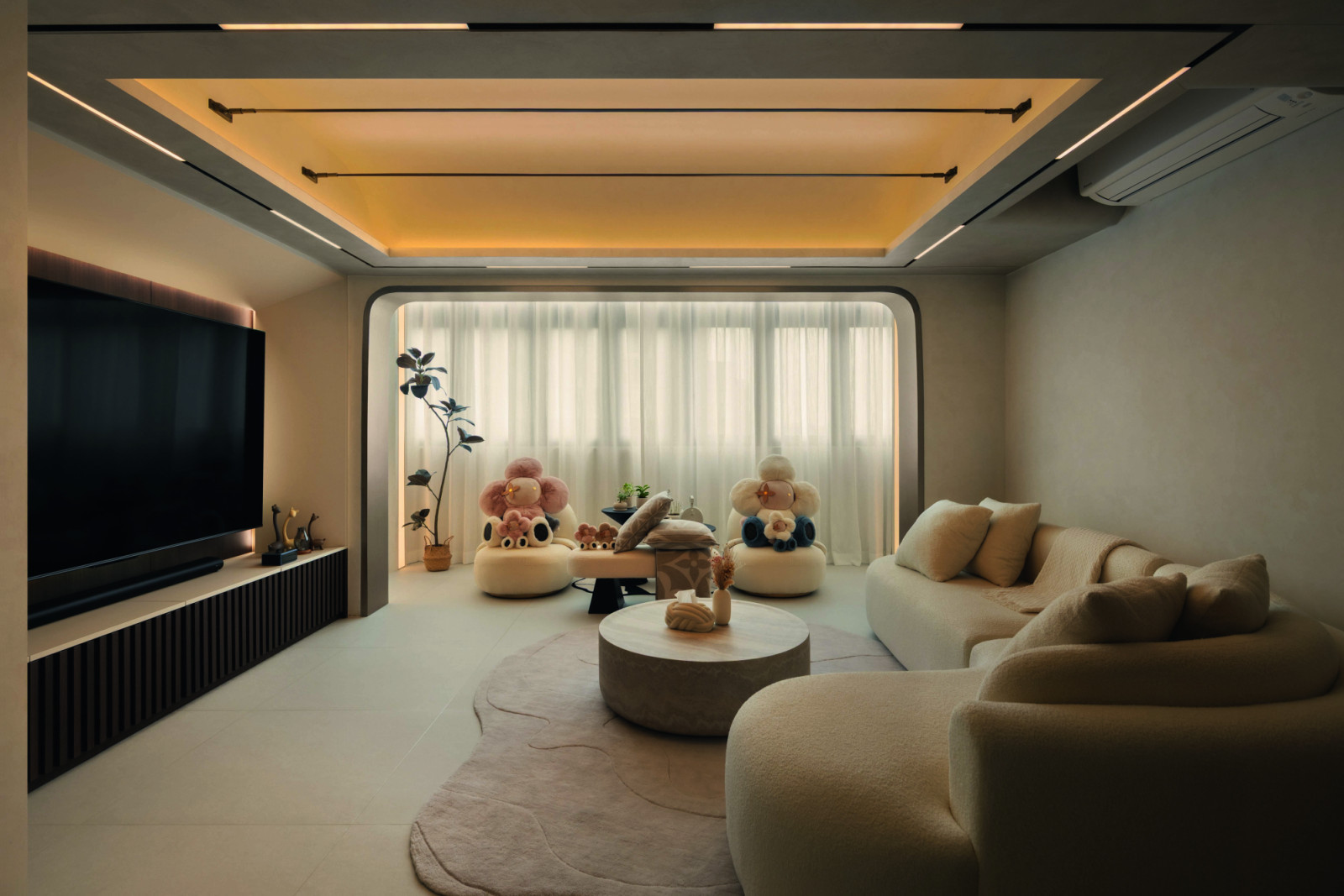 Curved portals and rounded furniture soften the linear symmetry of the living room while layered lighting overhead enhances its sense of height