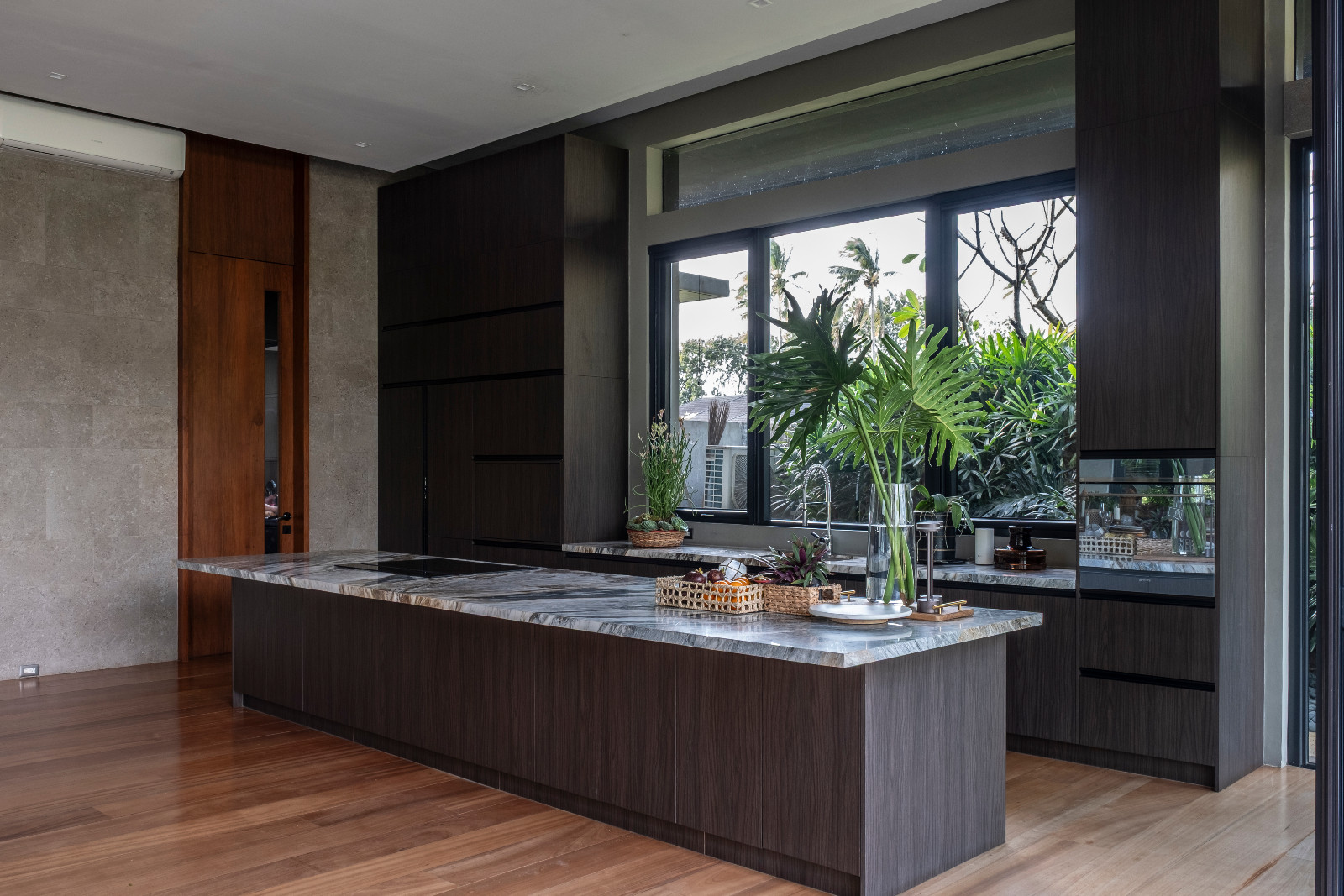The kitchen in a Batangas, Philippines home designed by LYS Architecture marrries wood and stone beautifully