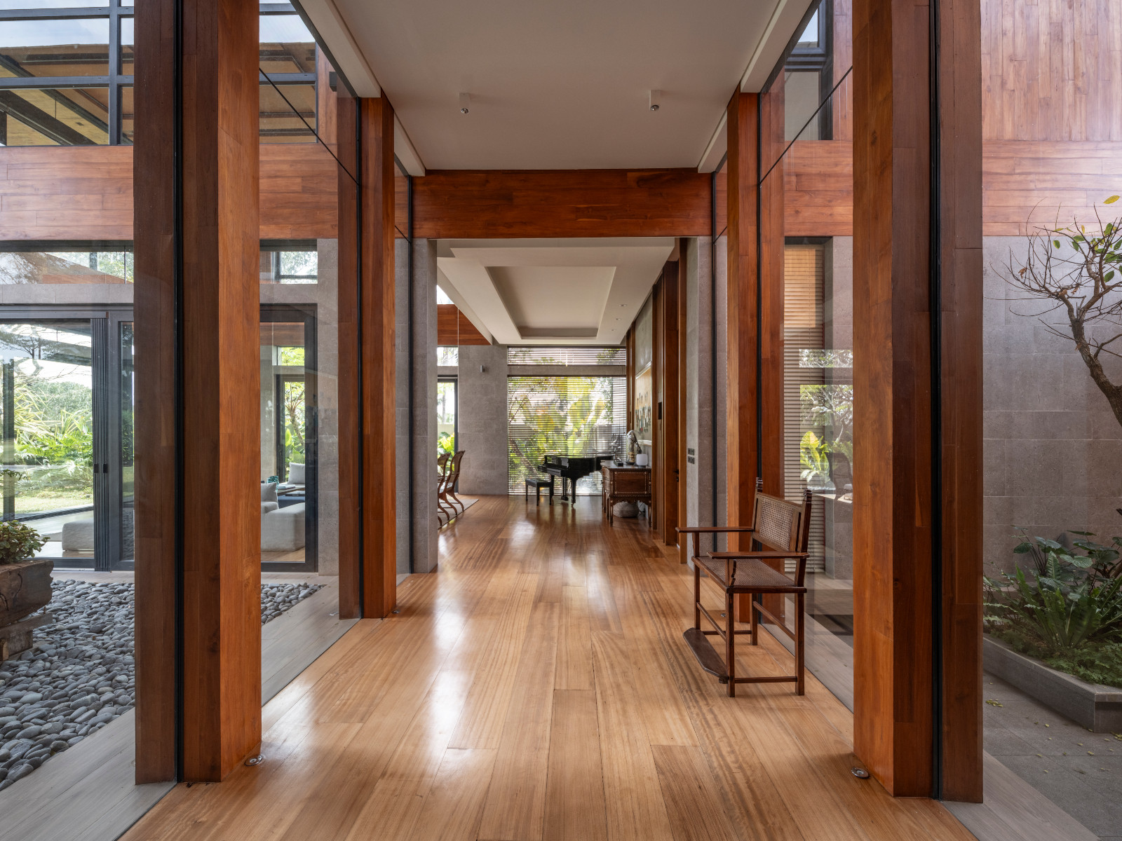The hallway highlights linear architectural elements which provide a modernist contrast to the antique furniture in a Batangas, Philippines home designed by LYS Architecture