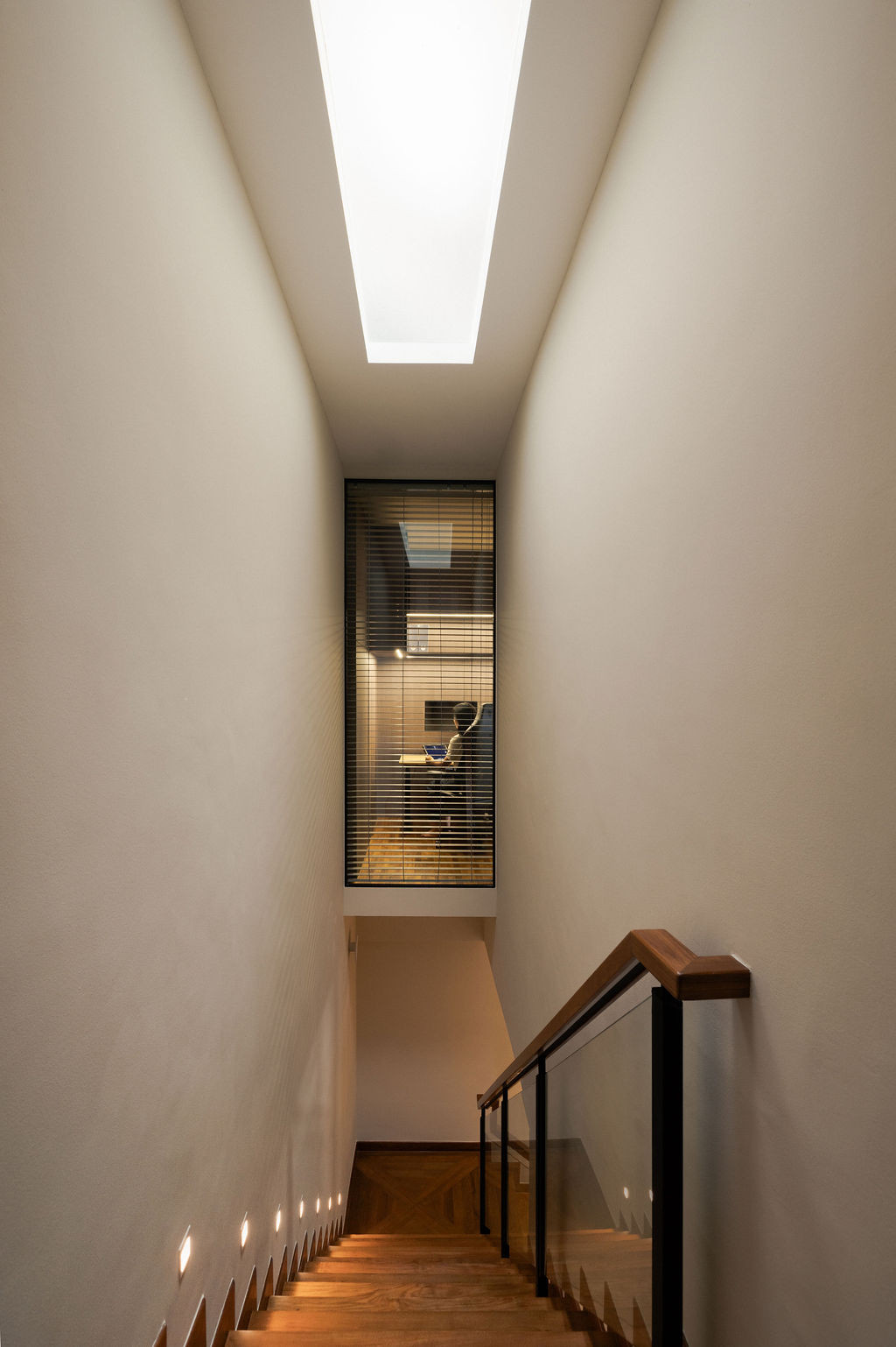 A linear skylight spans the top of the stairwell, casting natural light into the space and lifting the heaviness that once defined it