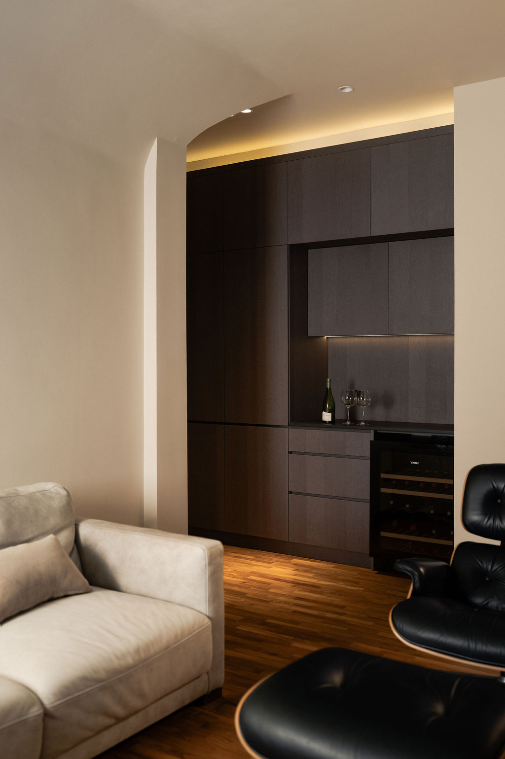 The lounge also boasts a custom-built bar concealed within matte timber cabinetry
