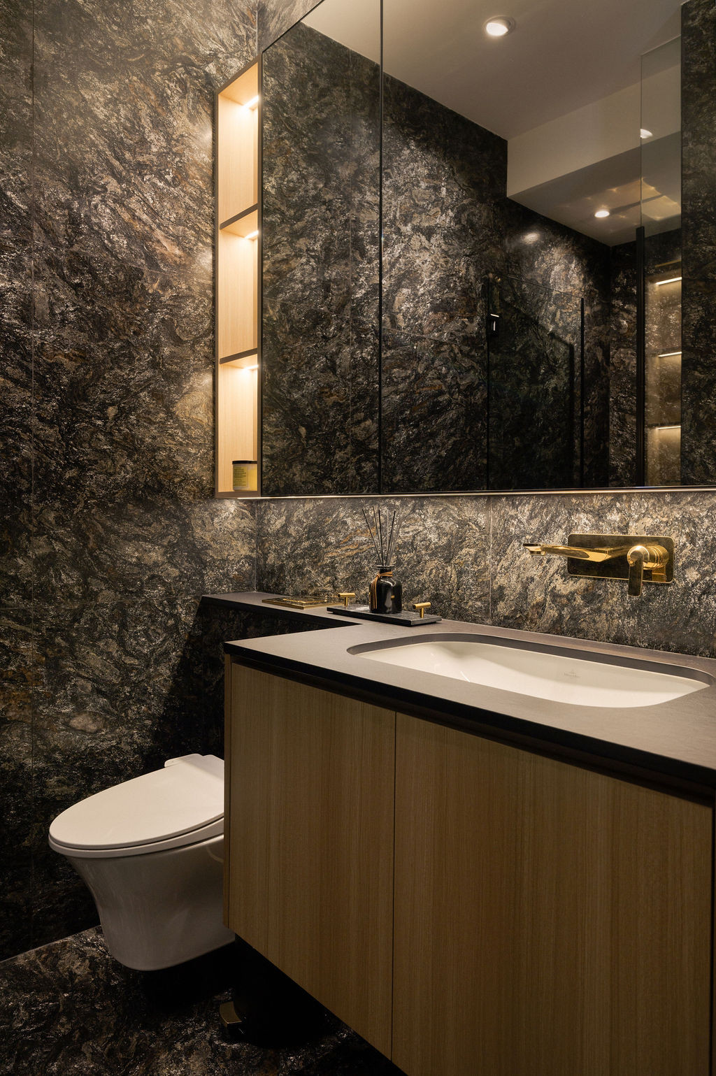 Metalicus Granite lends gravitas to this bathroom, paired with pale gold fittings designed by Carlo Colomboarch