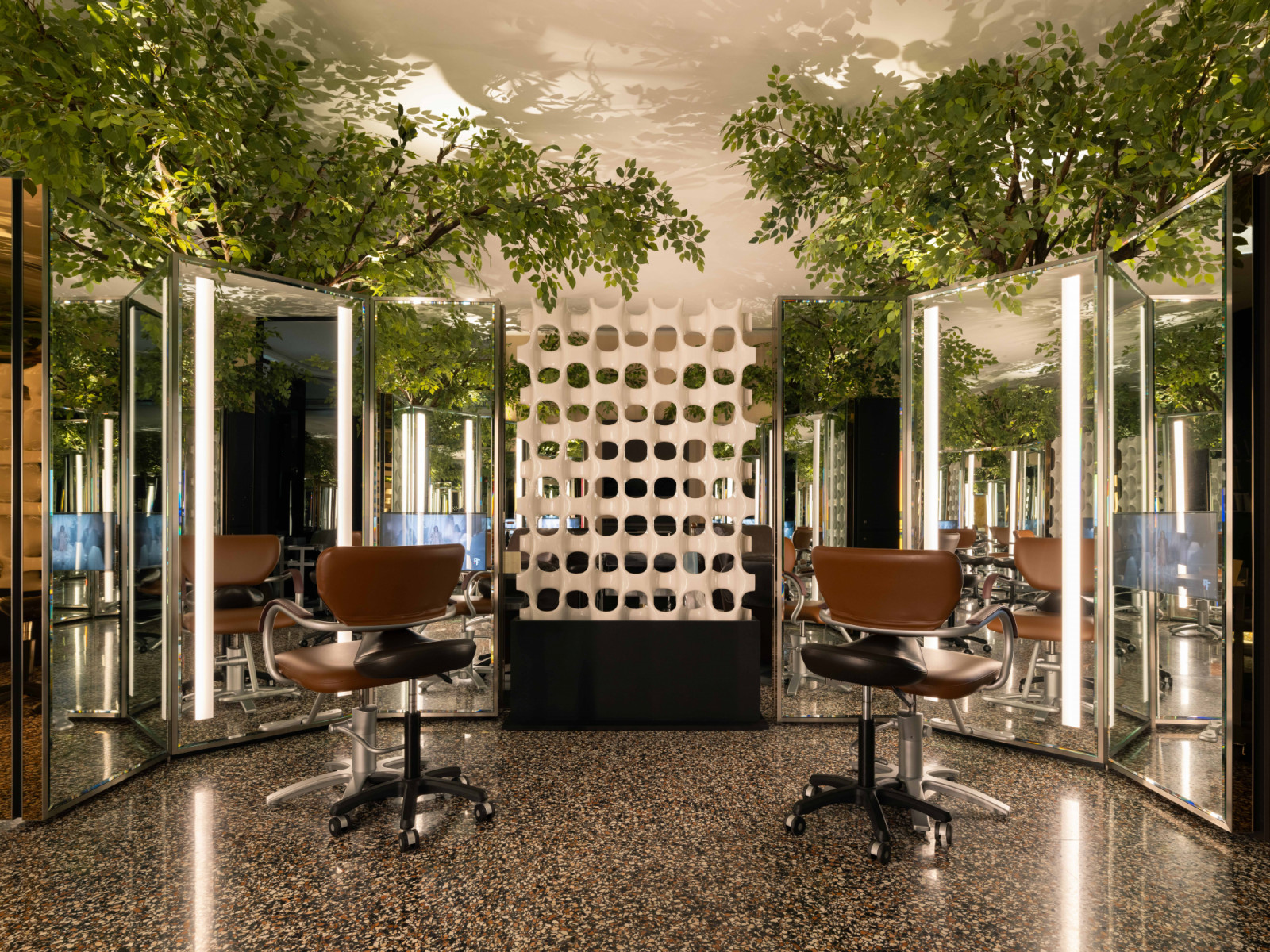 The main styling area features dry-cut stations arranged around a dramatic indoor forest