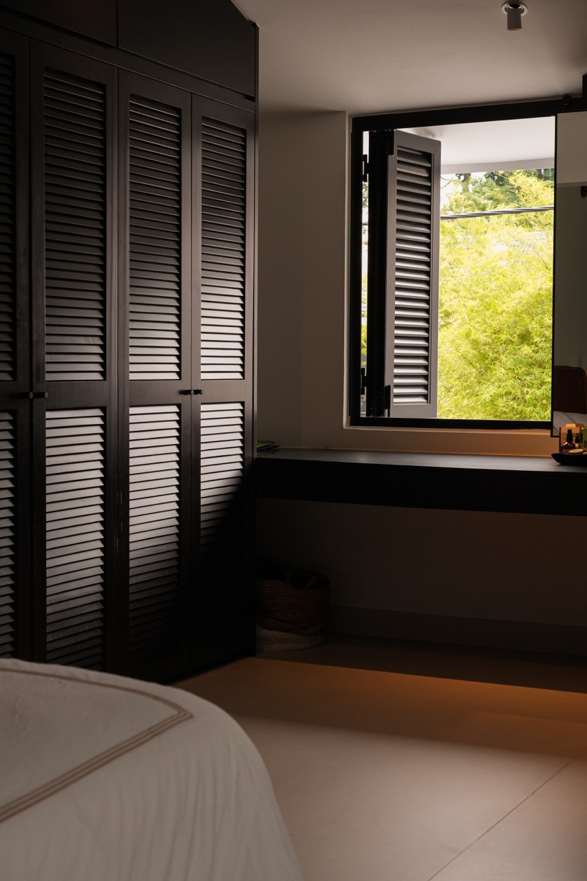 The master bedroom shows dark, solid wood louvred wardrobes and an open louvred window with green foliage visible outside