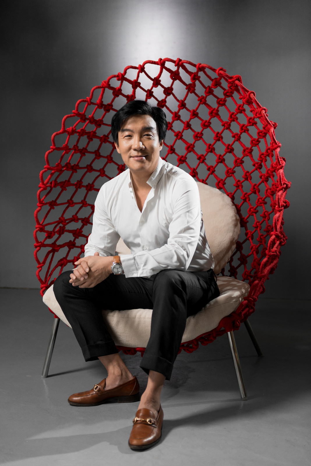 Designer Kenneth Cobonpue seated on the Dragnet chair