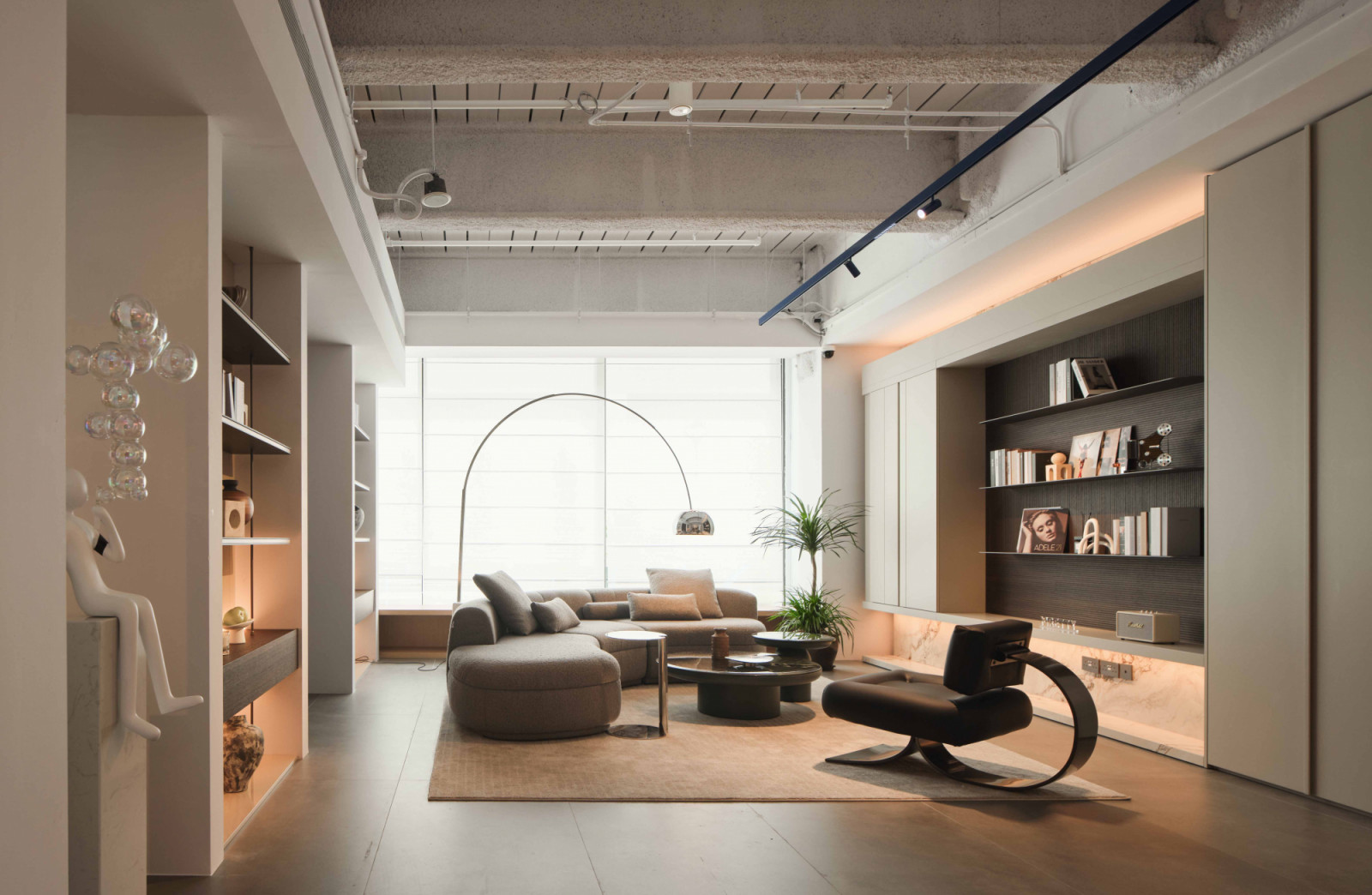 A softly layered living room composition in Mretty showroom highlights built-in shelving, warm lighting and restrained material palette