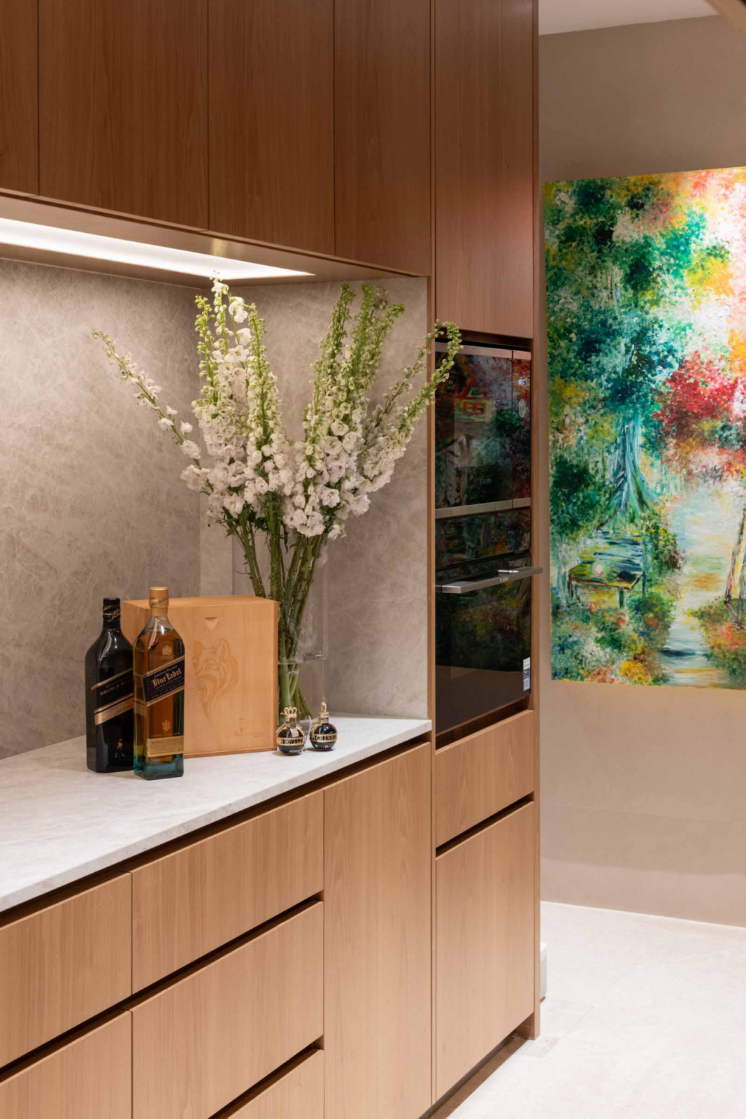 The sleek kitchen is adorned with a colourful artwork