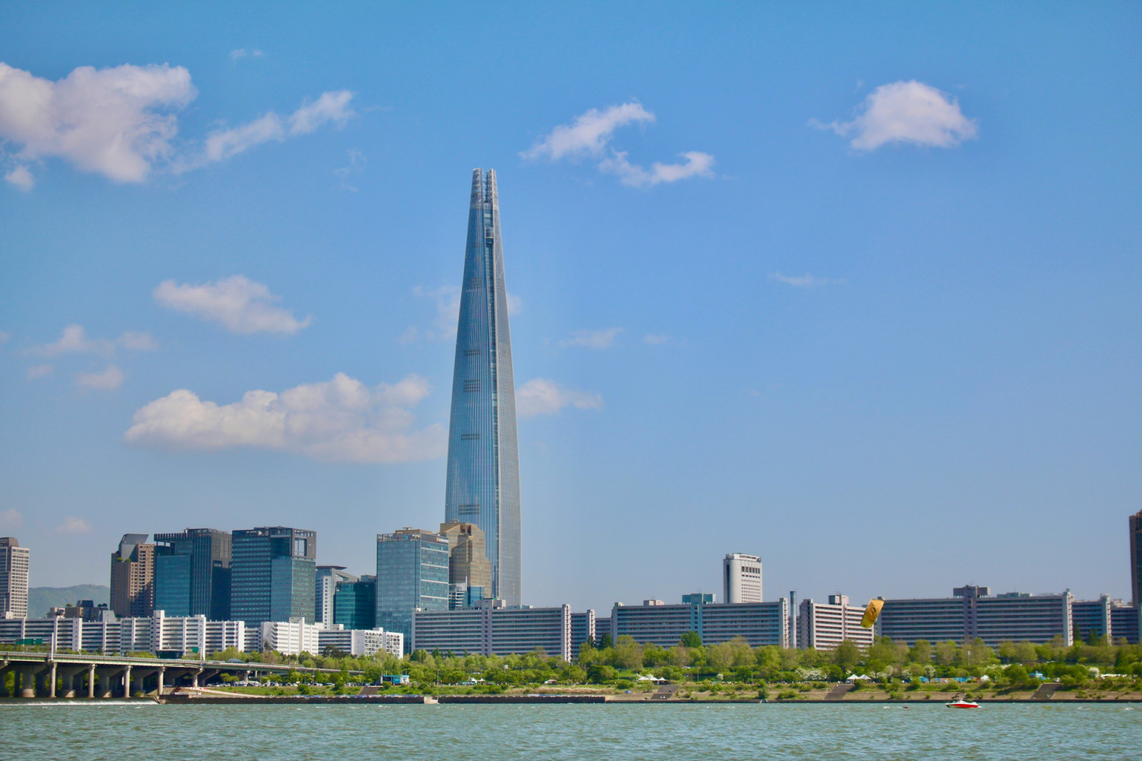 Lotte World Tower seen from across the Han River, its 555-metre height placing it well above the surrounding low-rise fabric of eastern Seoul (Photo: Unsplash/Park Gunwoo)