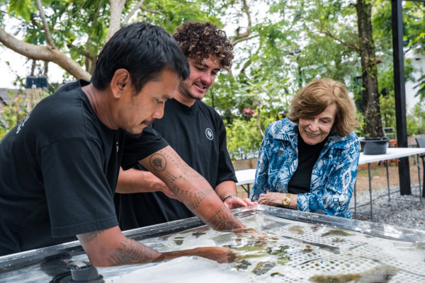 Coral Gardeners founder and CEO Titouan Bernicot (pictured centre) with Khun Yod Aekchai (far left), a team member at Coral Gardeners’ Thai outpost, presenting land‑based nursery corals to Rolex Testimonee Sylvia Earle