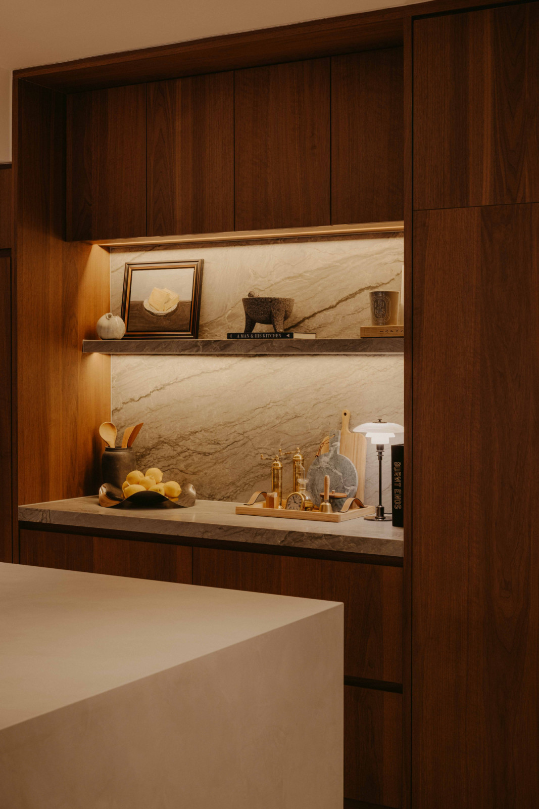 In the dry kitchen of this West Coast home, a marble-lined niche and backsplash form a compact prep and display zone, finished in Sensa Platino